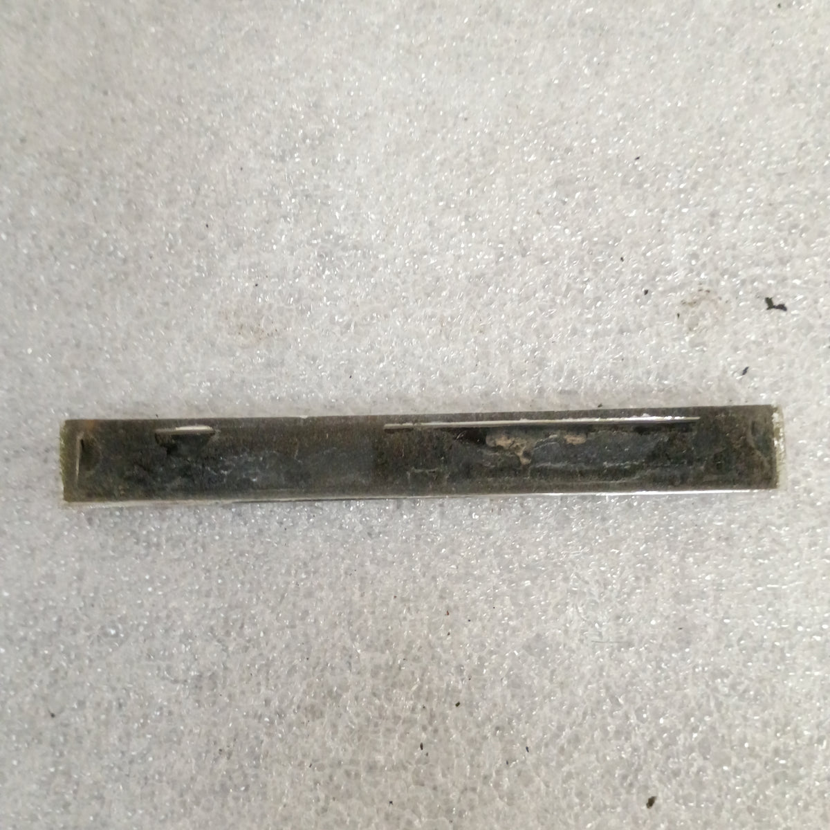 Ford XLT Diesel fender or tailgate emblem, showing wear, with black and metallic finish on a textured background.