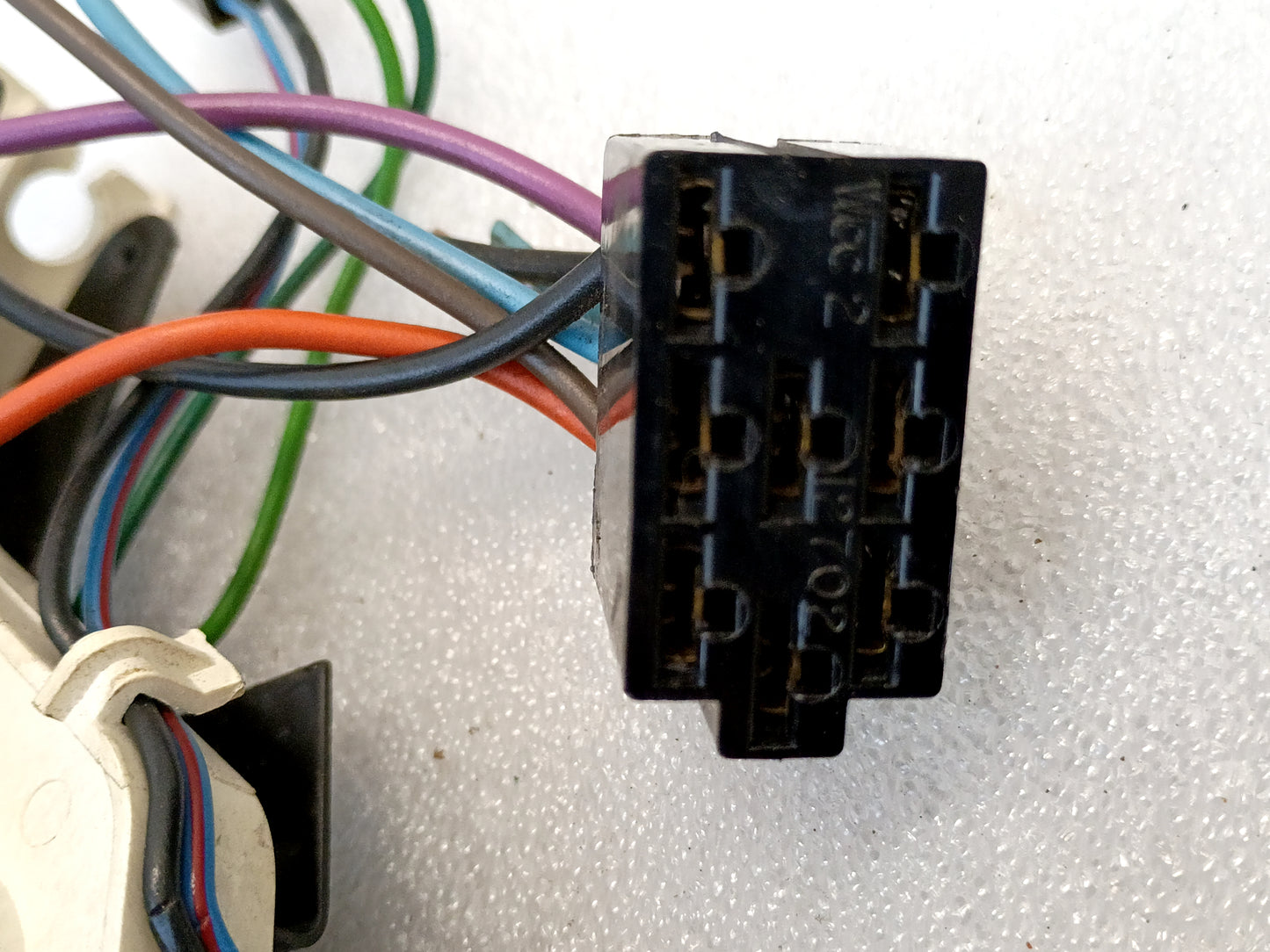 Close-up of a black connector with multiple colored wires attached, part of a Ford OEM heater and AC control system.