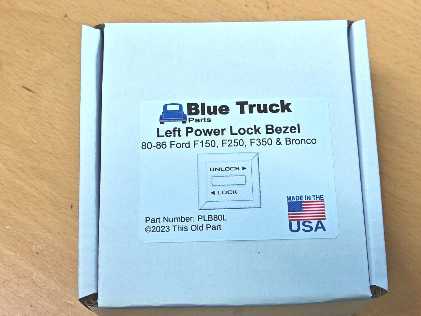 Blue Truck Parts packaging box for a Left Power Lock Bezel, compatible with 1980-1986 Ford F150, F250, F350, and Bronco. Label includes part number PLB80L and a Made in the USA logo.