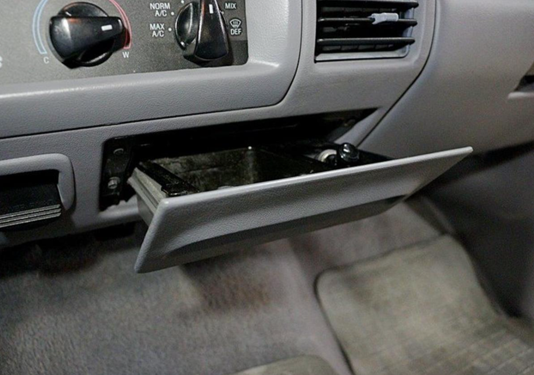 Ashtray pulled open in the dash of a 1992-1996 Ford F-150 with a gray interior