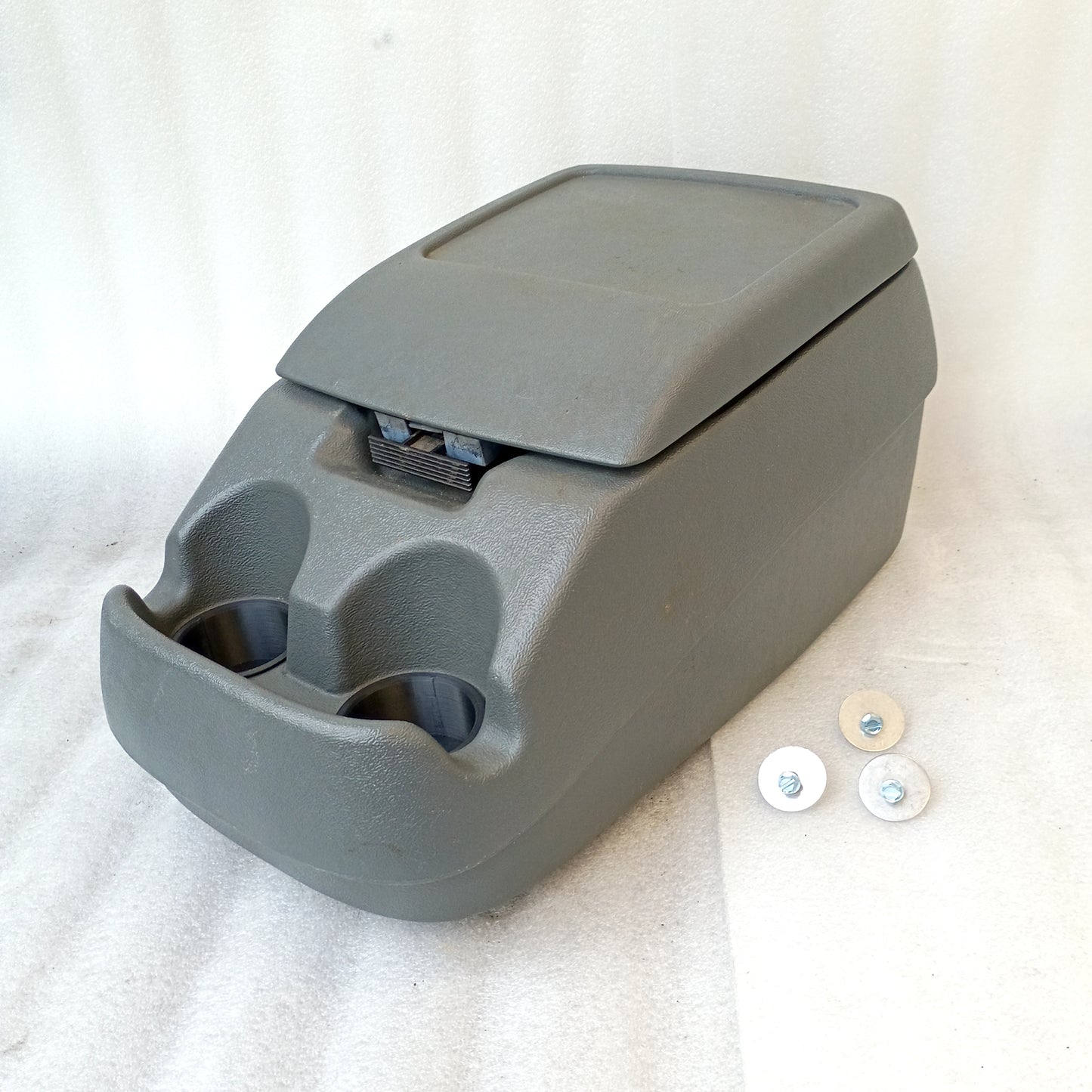 Dark gray center console with two cup holders, latch, and mounting bolts for 1992-1997 Ford trucks and Bronco.