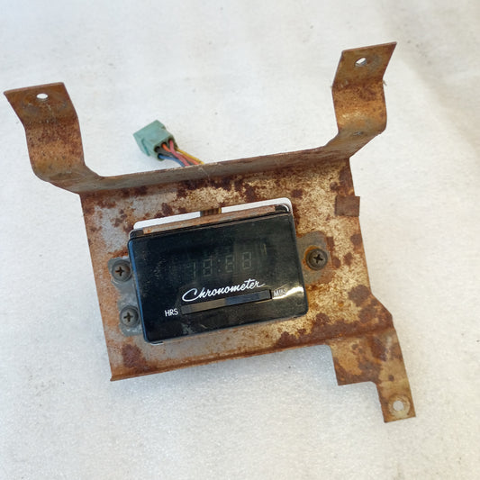 Dodge chronometer clock for 1981-1989 Ram models, mounted on a rusty bracket, compatible with D100, D150, D250, Ramcharger.
