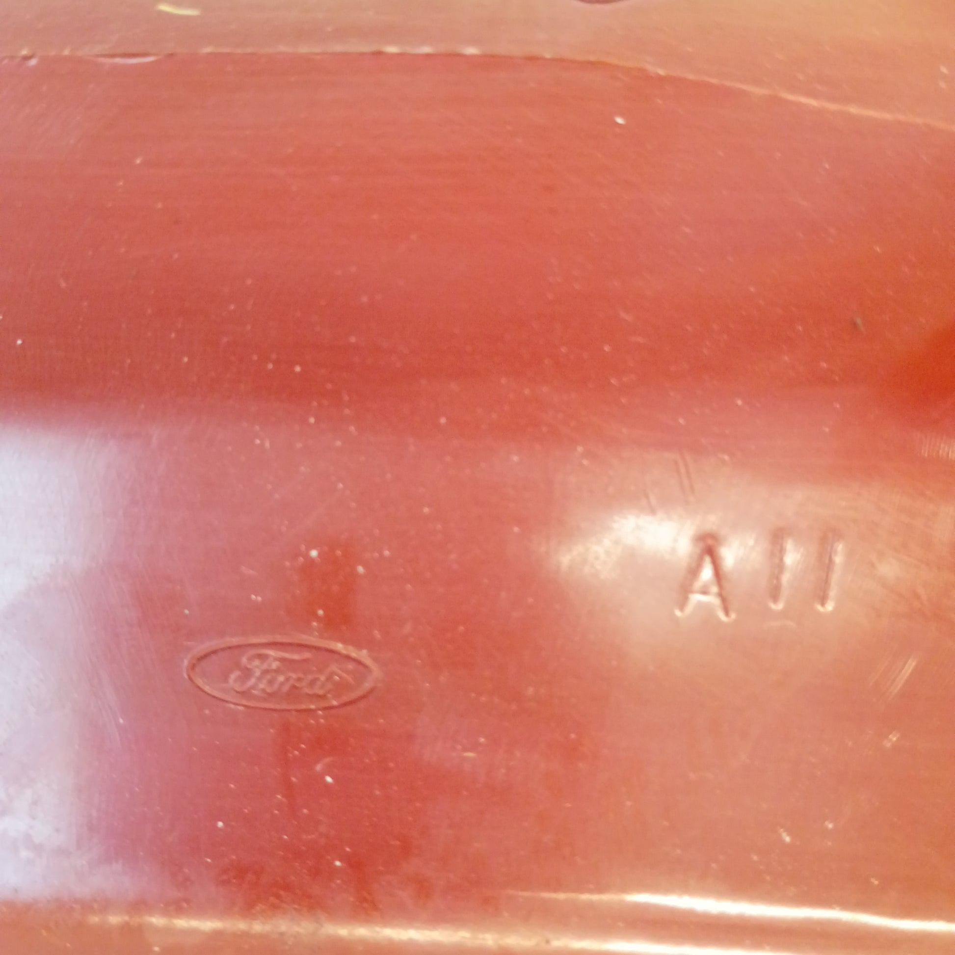 Close-up of red A-pillar trim piece for 1980-1986 Ford F-Series/Bronco, featuring a Ford logo and embossed "A11".