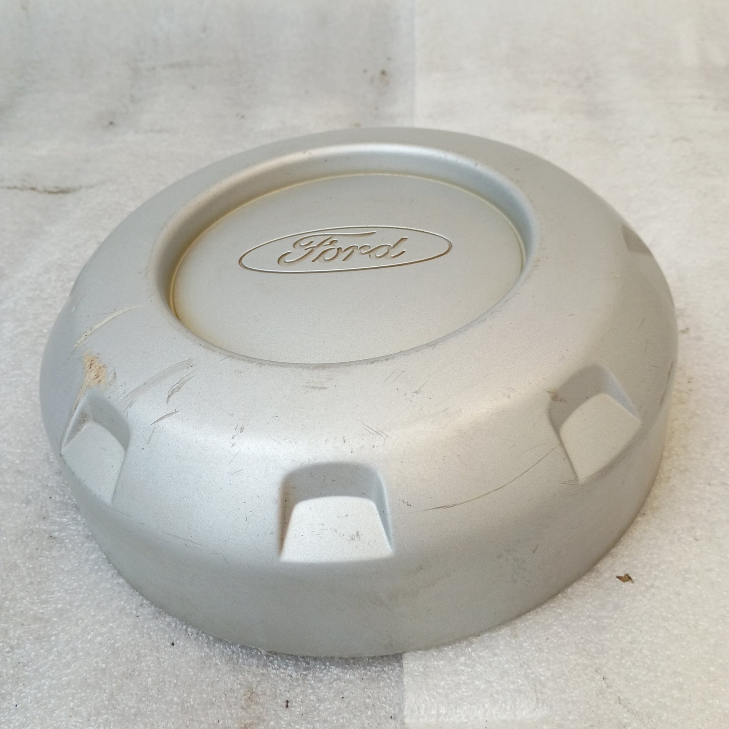 Silver Ford center hub cap with solid face and logo, clips onto lug nuts. Compatible with 1999-2004 F-250/F-350 Super Duty.