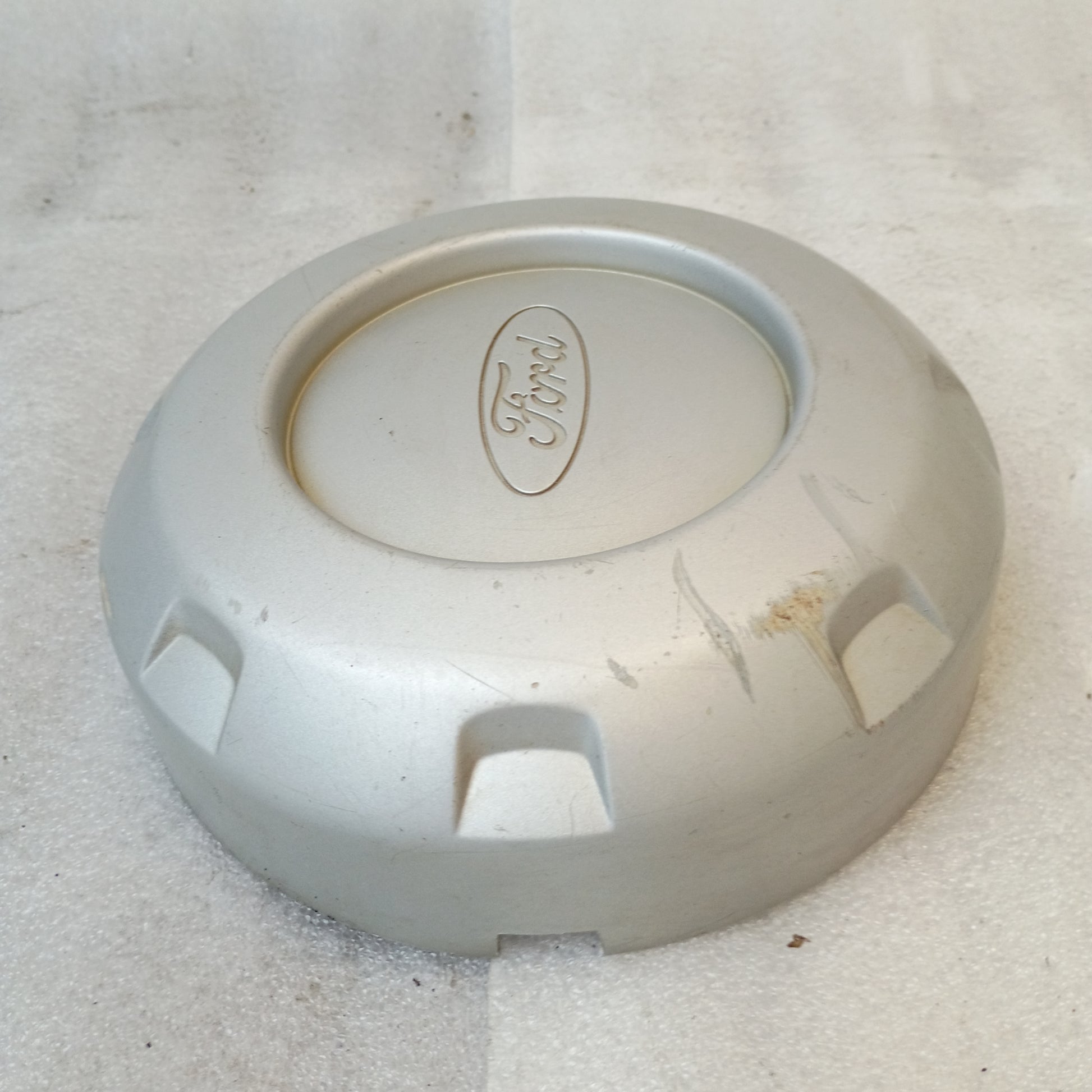 Silver Ford center hub cap with logo, solid face, compatible with 1999-2004 F-250 and F-350 Super Duty models.