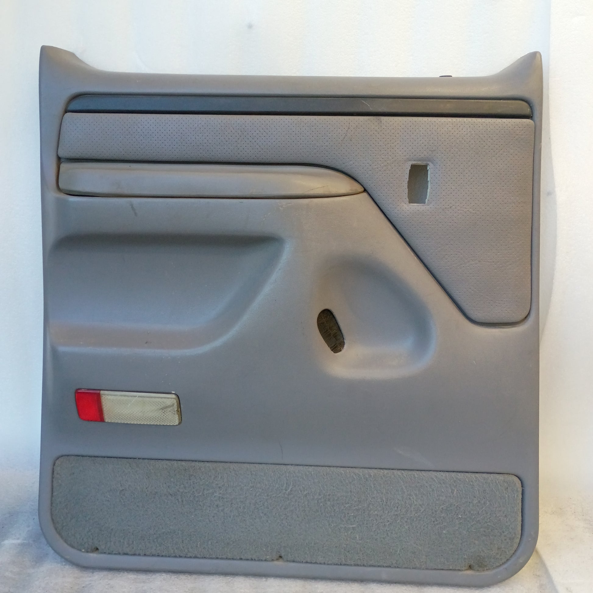 Deluxe light gray rear crew cab door panel for 1992-1997 Ford F250/F350, features vinyl armrest and red reflector.