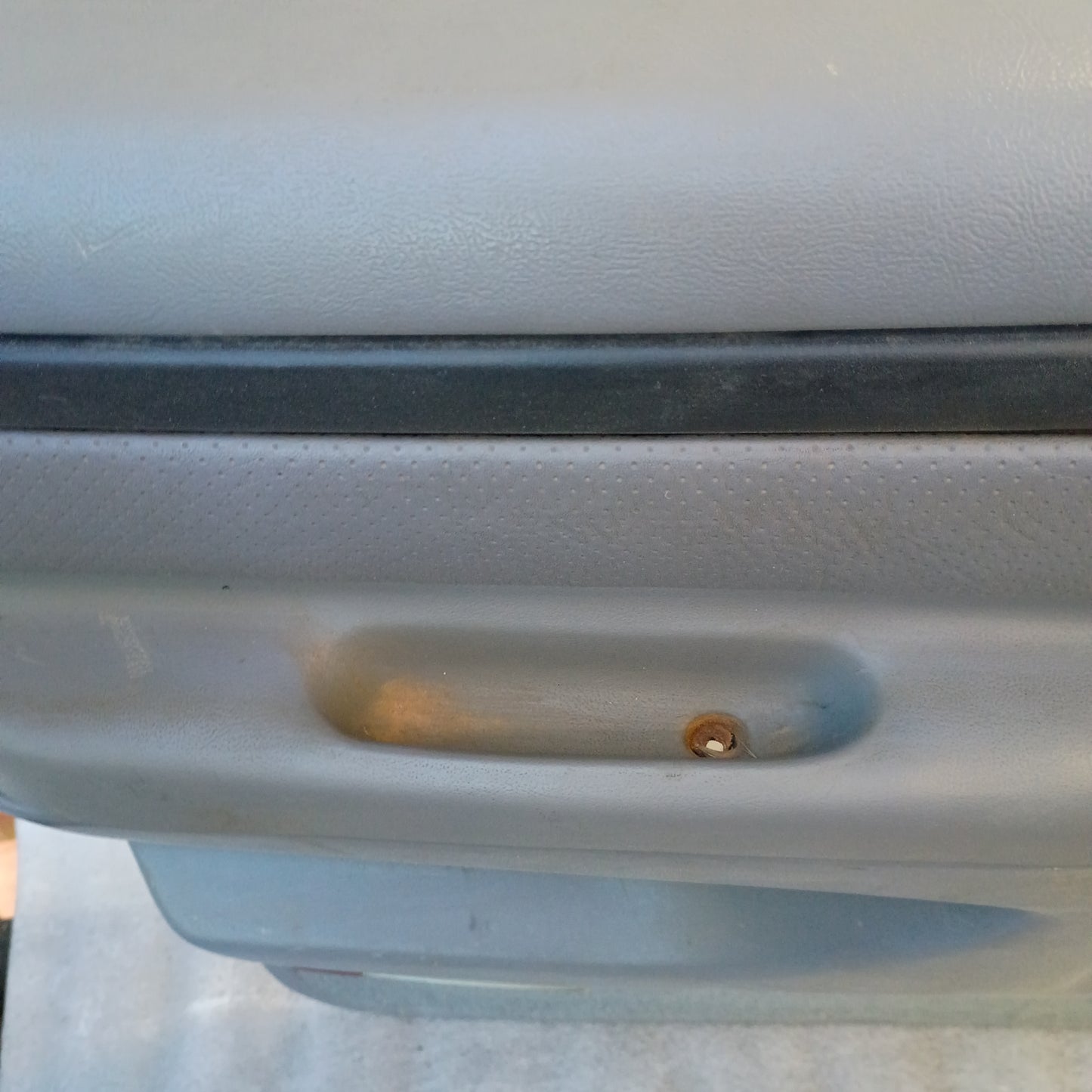 Light gray Ford truck rear door panel with vinyl armrest and visible mounting hole, compatible with 1992-1997 F-series models.