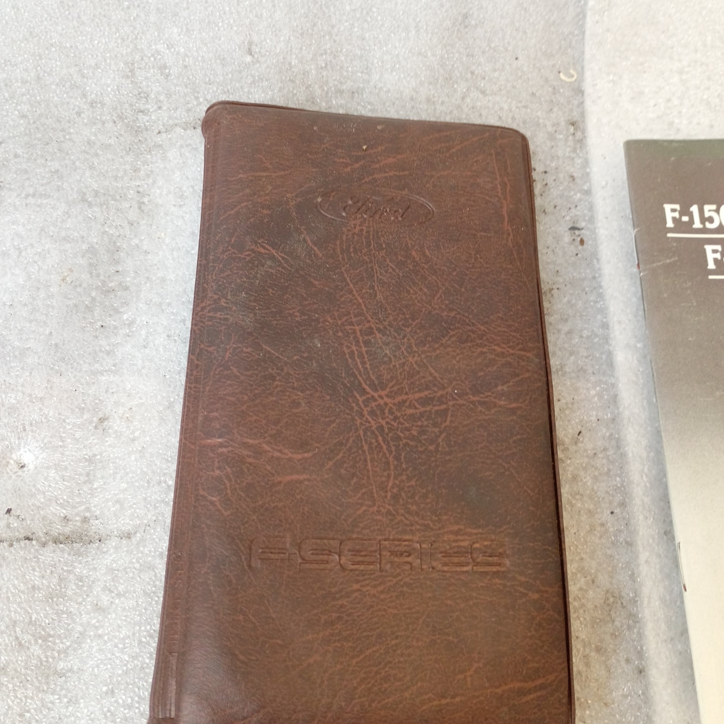 Brown vinyl padded cover of a 1990 Ford F-Series manual set with embossed "F-Series" text.
