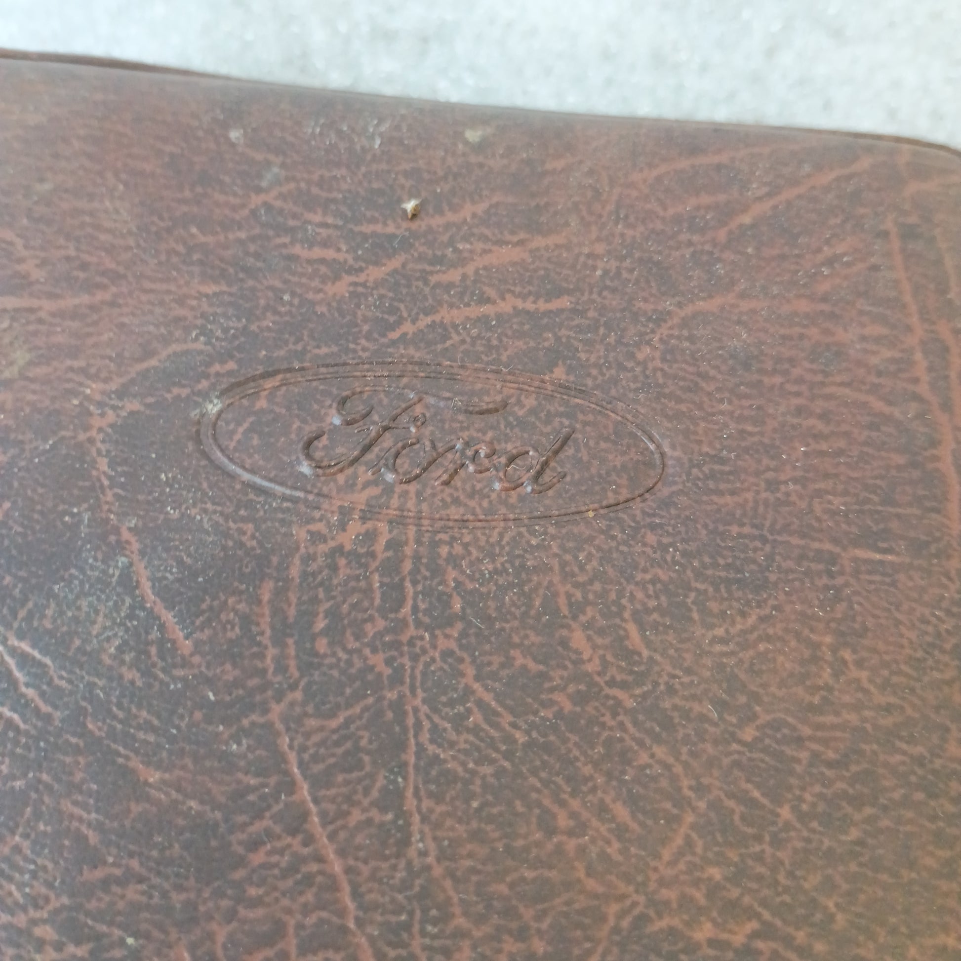 Brown vinyl padded cover with embossed Ford logo, part of the 1990 Diesel F-Series Owner Guide and Maintenance Schedule set.
