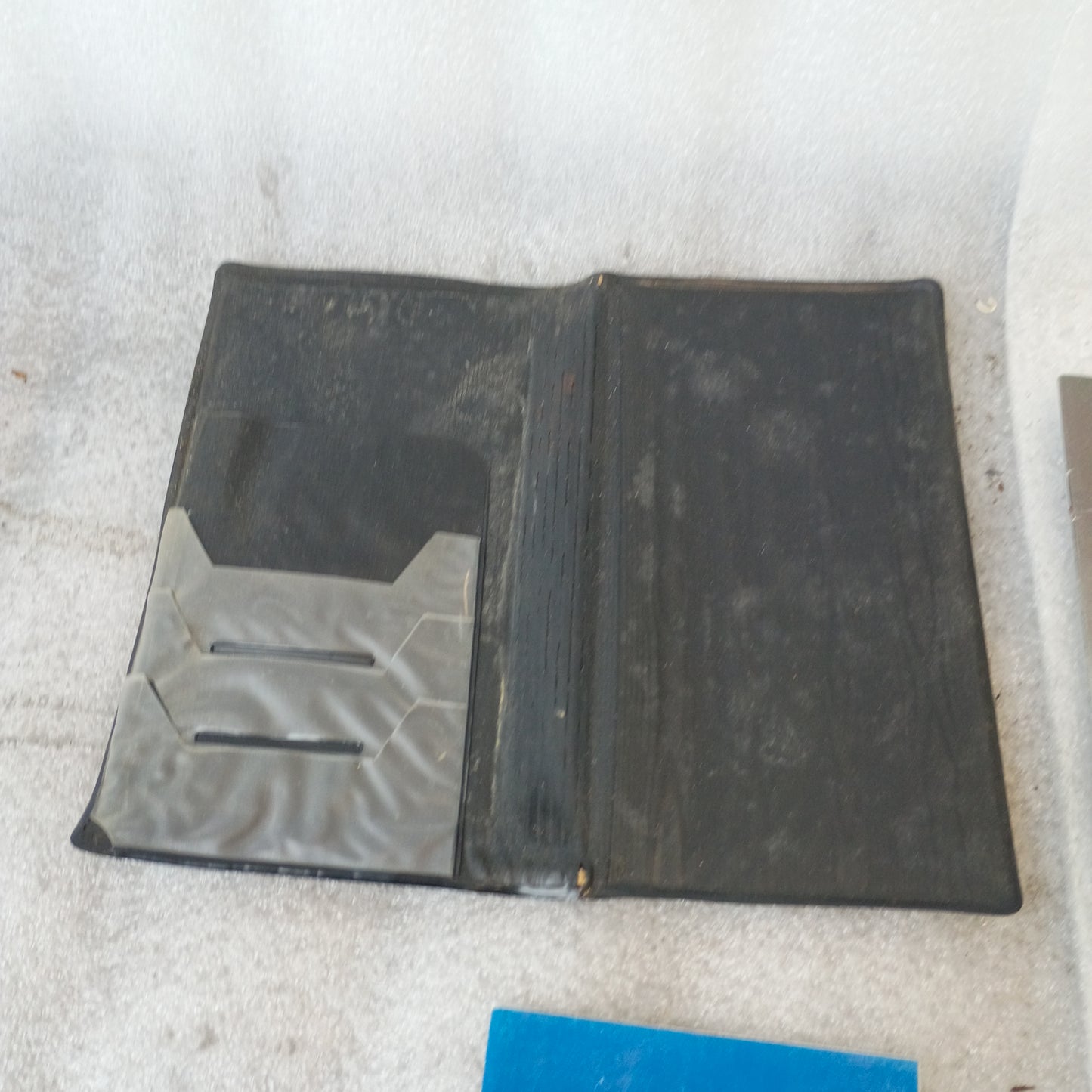 Brown vinyl padded cover for 1990 Ford F-Series and Bronco manuals, open with visible pocket slots.