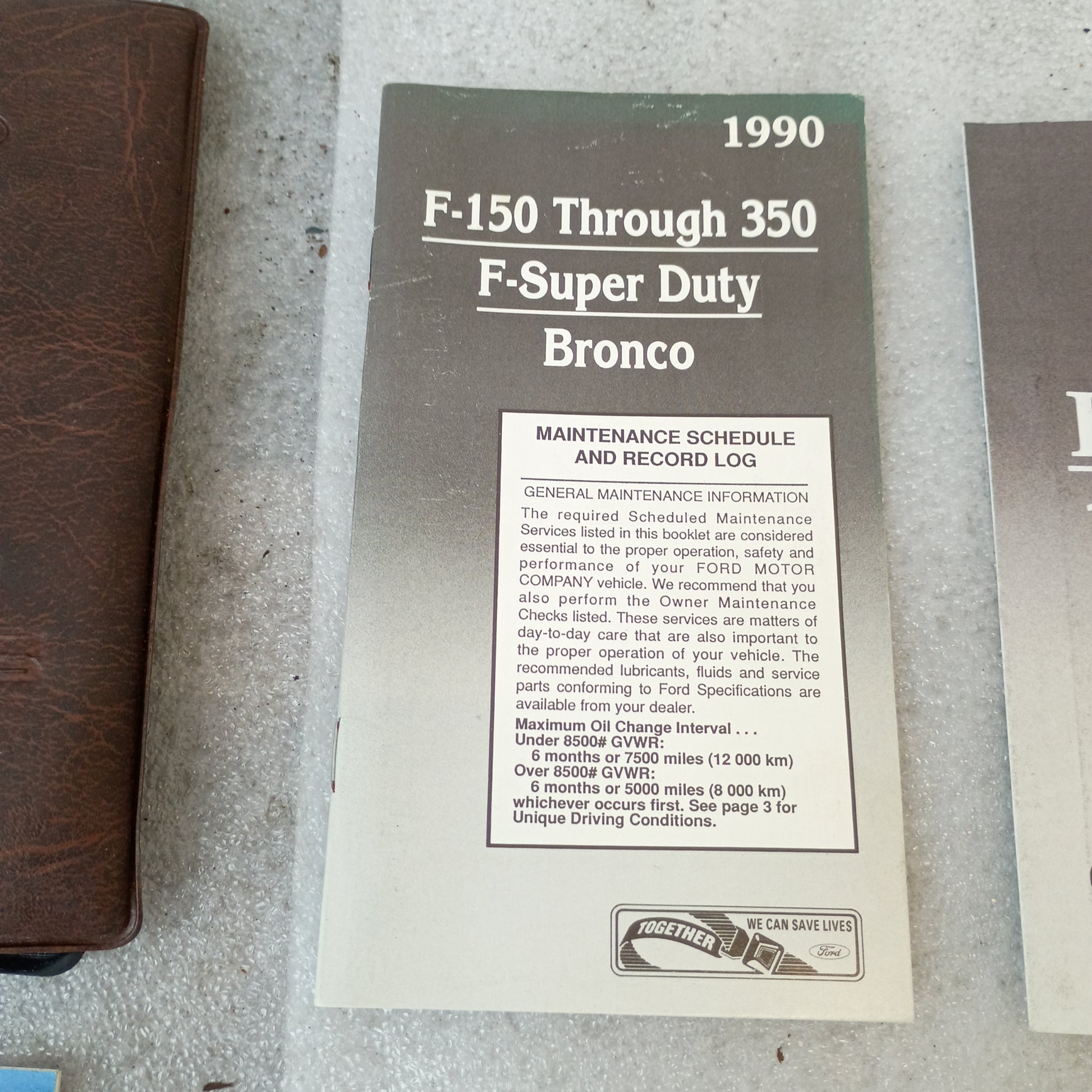 1990 Ford F-150 to F-350 Bronco maintenance schedule booklet, featuring brown vinyl cover and maintenance log details.