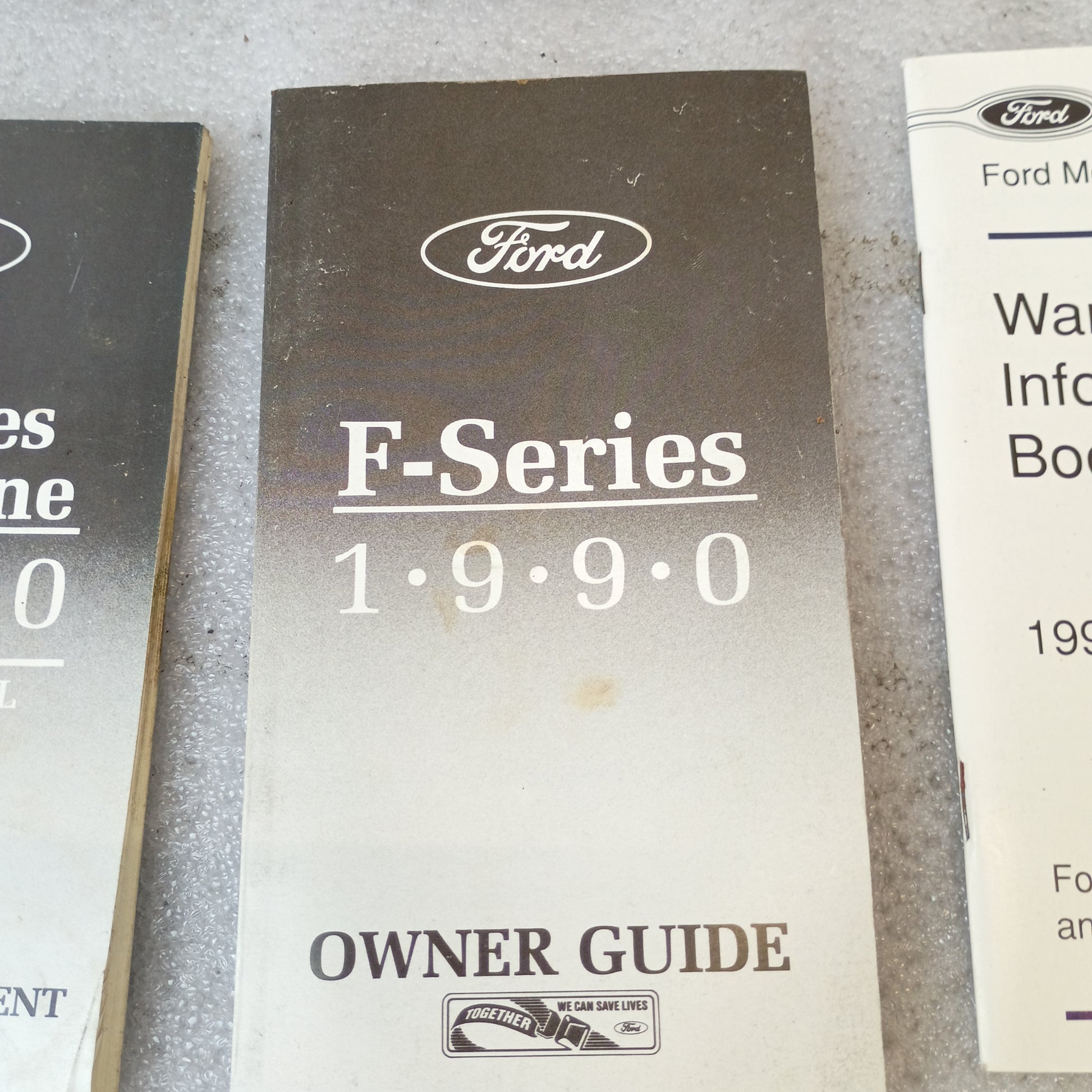 1990 Ford F-Series Owner Guide with "Owner Guide" text, vintage manual for F150-F350 trucks, on a textured surface.