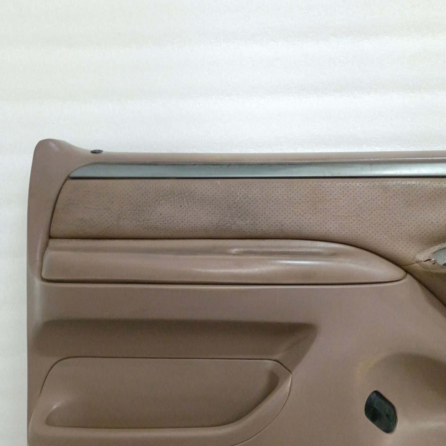 Tan Ford deluxe door panel for 1992-1997 F150/F250/F350/Bronco, with silver and black trim and vinyl armrest.