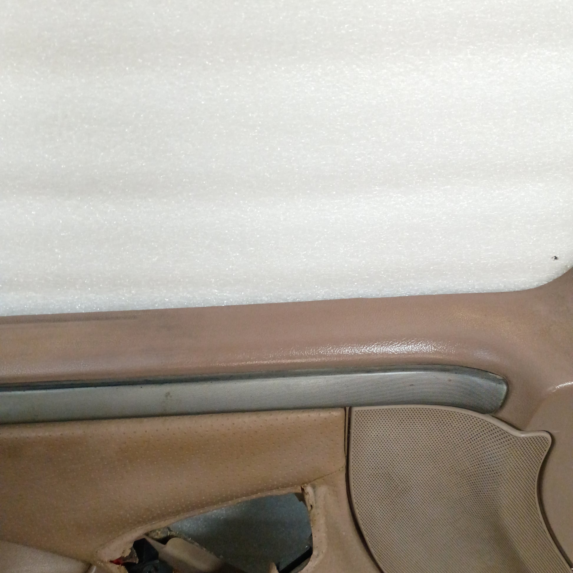 Tan deluxe door panel for Ford F150/F250/F350/Bronco, featuring silver trim with black lines. Shows slight wear on top edge.