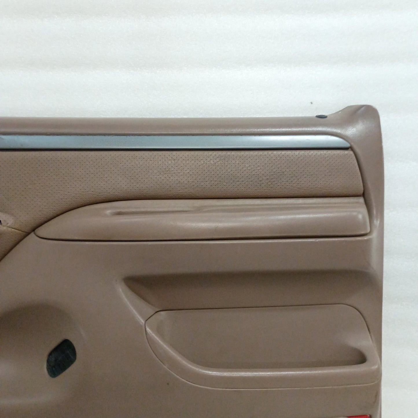 Tan Ford door panel with silver trim, vinyl armrest, and map pocket. Designed for 1992-1997 Ford F-150, F-250, F-350, Bronco.