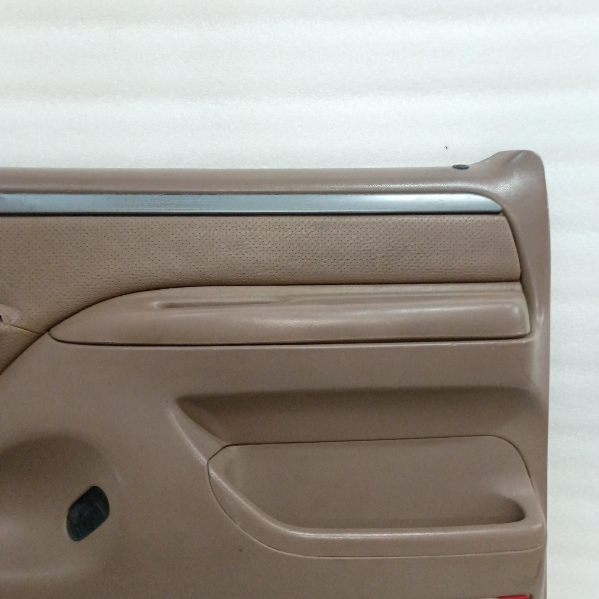 Tan Ford door panel with silver trim, vinyl armrest, and map pocket. Designed for 1992-1997 Ford F-150, F-250, F-350, Bronco.