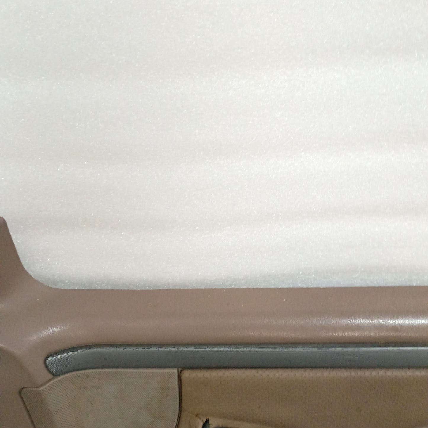 Tan deluxe door panel for Ford F150-F350 and Bronco, showing silver trim with black lines and partial vinyl texture.