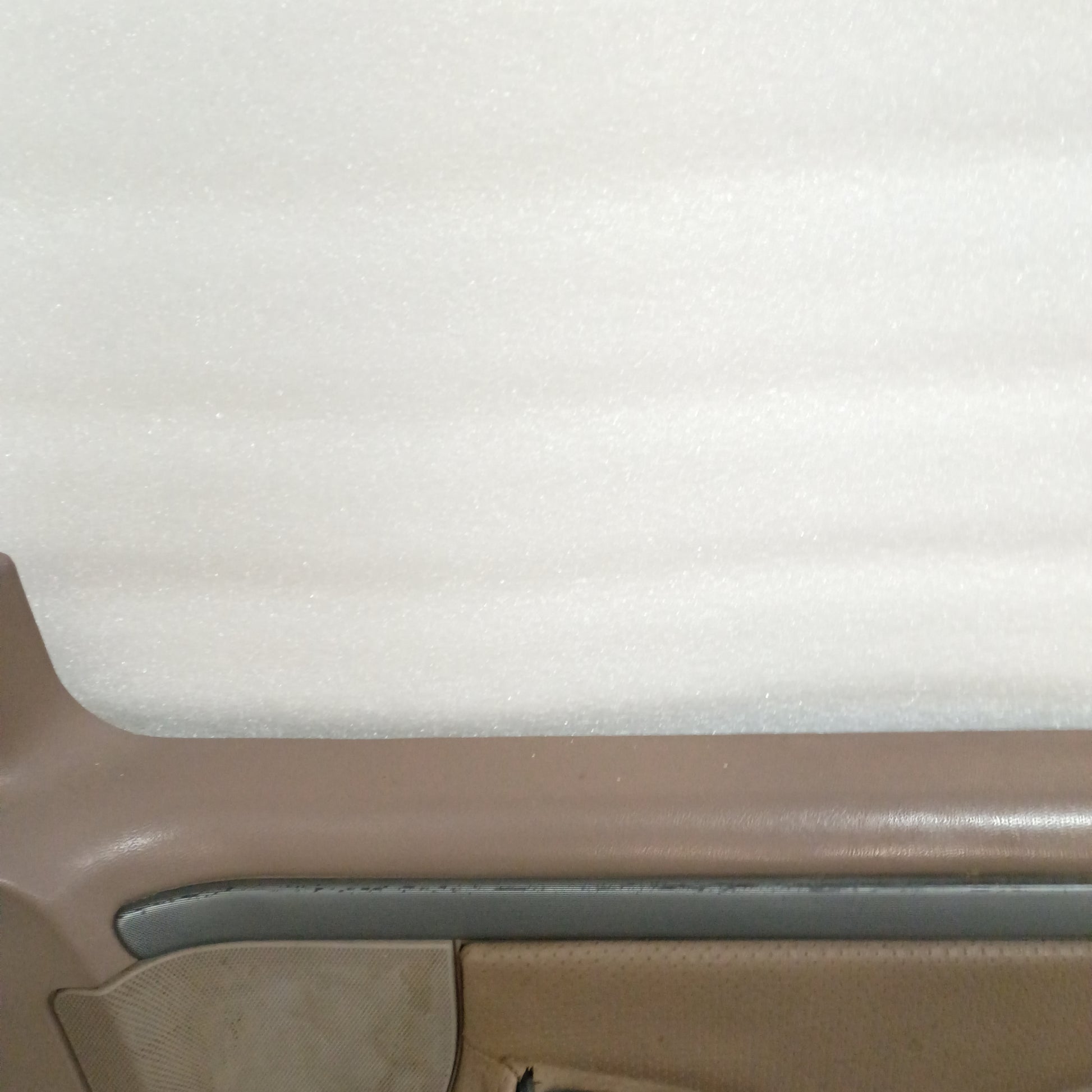 Tan deluxe door panel for Ford F150-F350 and Bronco, showing silver trim with black lines and partial vinyl texture.