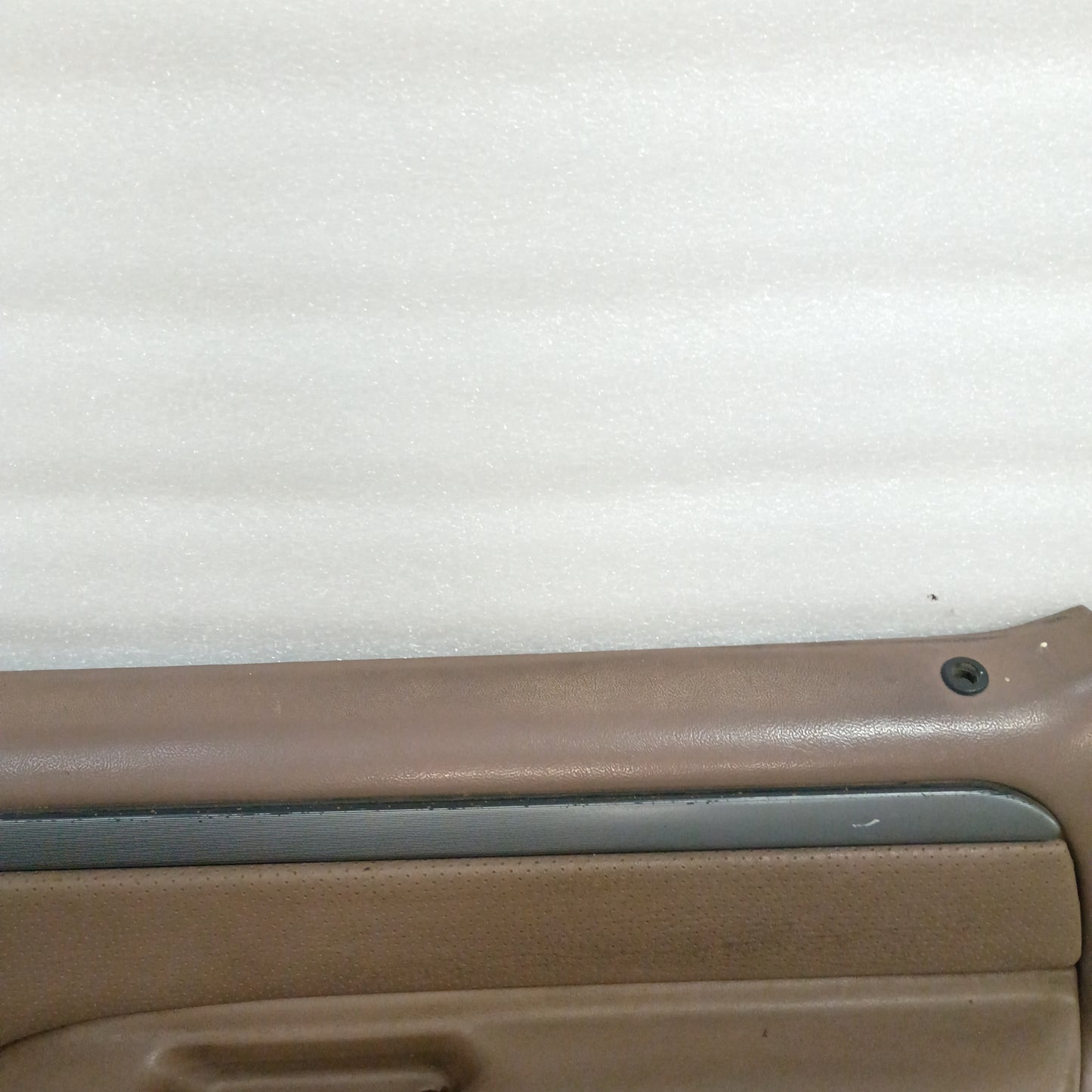 Tan door panel for 1992-1997 Ford trucks, featuring silver trim with black lines and minor wear on the top edge.