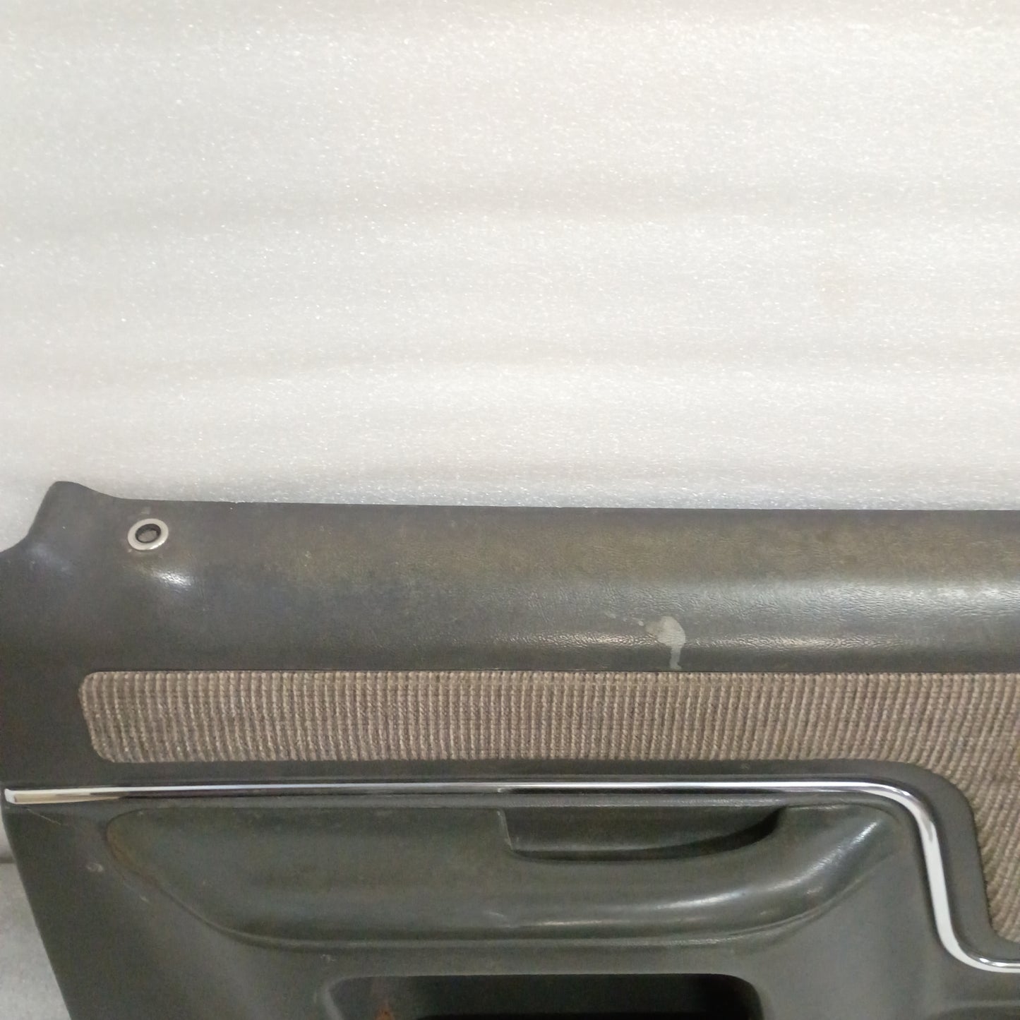 Dark gray door panel with chrome trim and carpeted insert for 1987-1991 Ford truck models. Manual window and lock design.