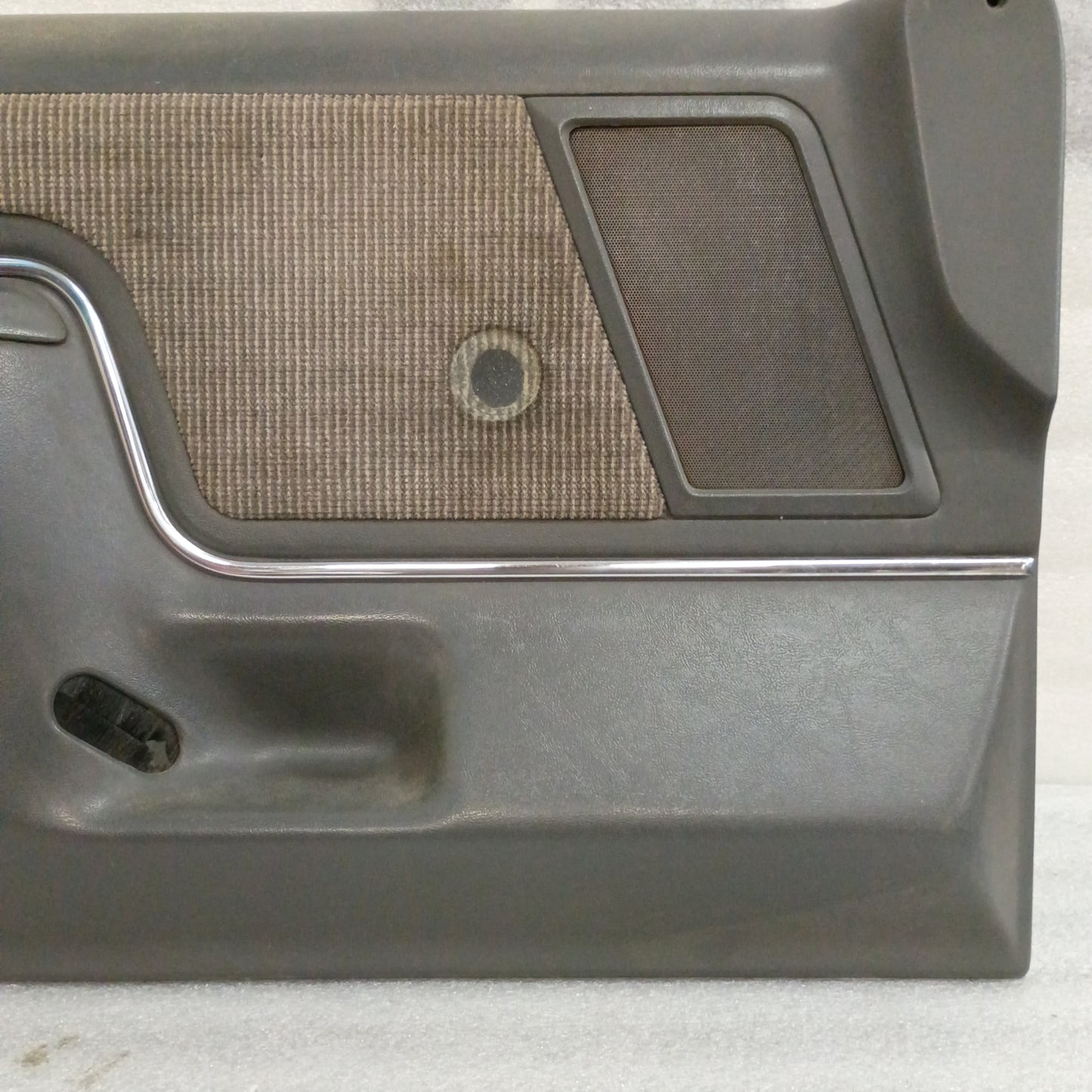 Dark gray Ford door panel with carpeted map pocket and speaker grille, suitable for 1987-1991 F-series trucks and Bronco.