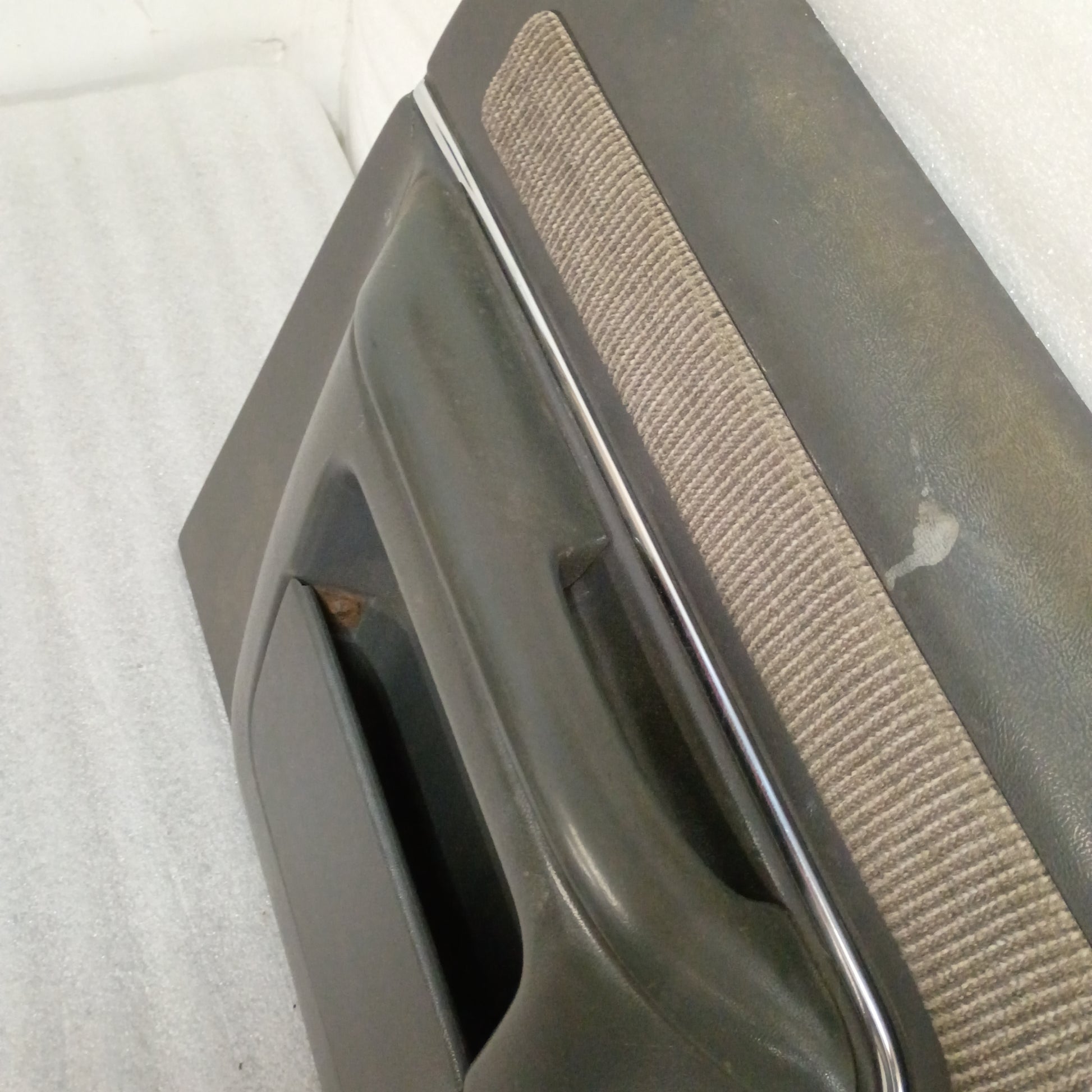 Dark gray Ford door panel with manual window crank, chrome trim, and carpeted map pocket insert for 1987-1991 F-Series.