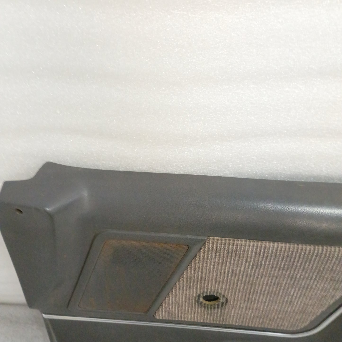 Dark gray Ford door panel for manual windows, features a carpeted map pocket, speaker grille in good condition, compatible with 1987-1991 F150/F250/F350/Bronco.