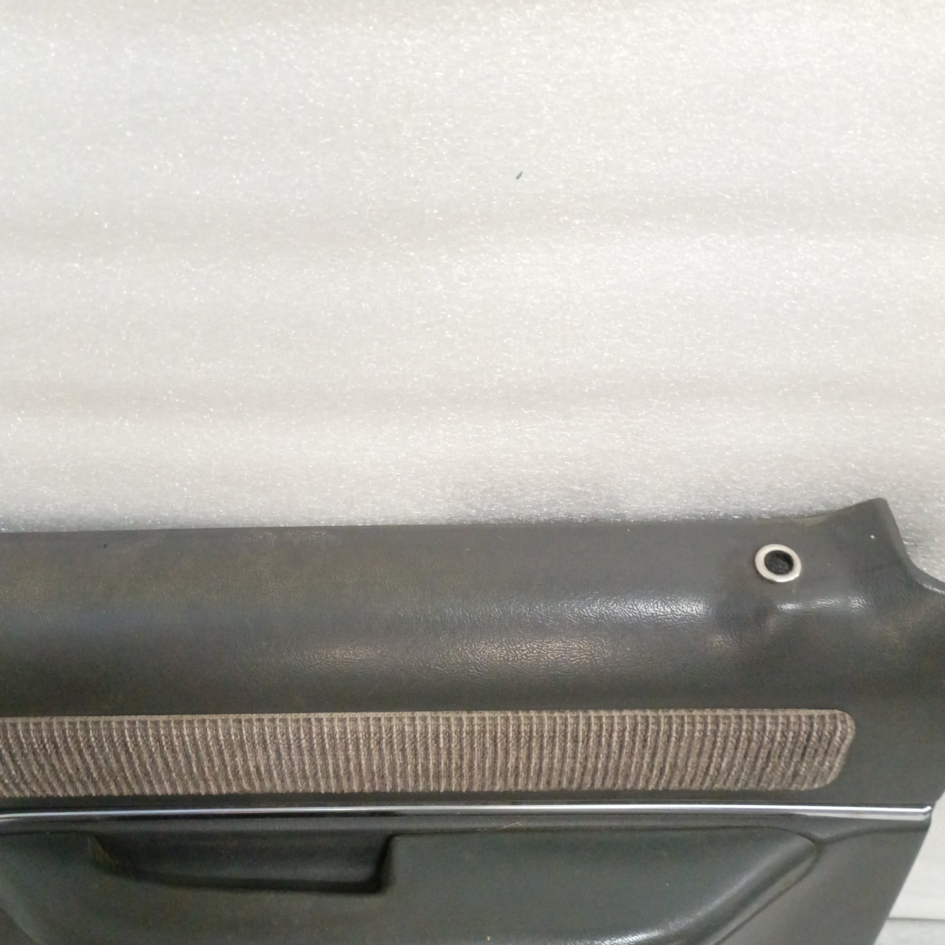 Dark gray Ford door panel with textured insert and chrome trim, designed for manual windows, compatible with 1987-1991 F-Series and Bronco.
