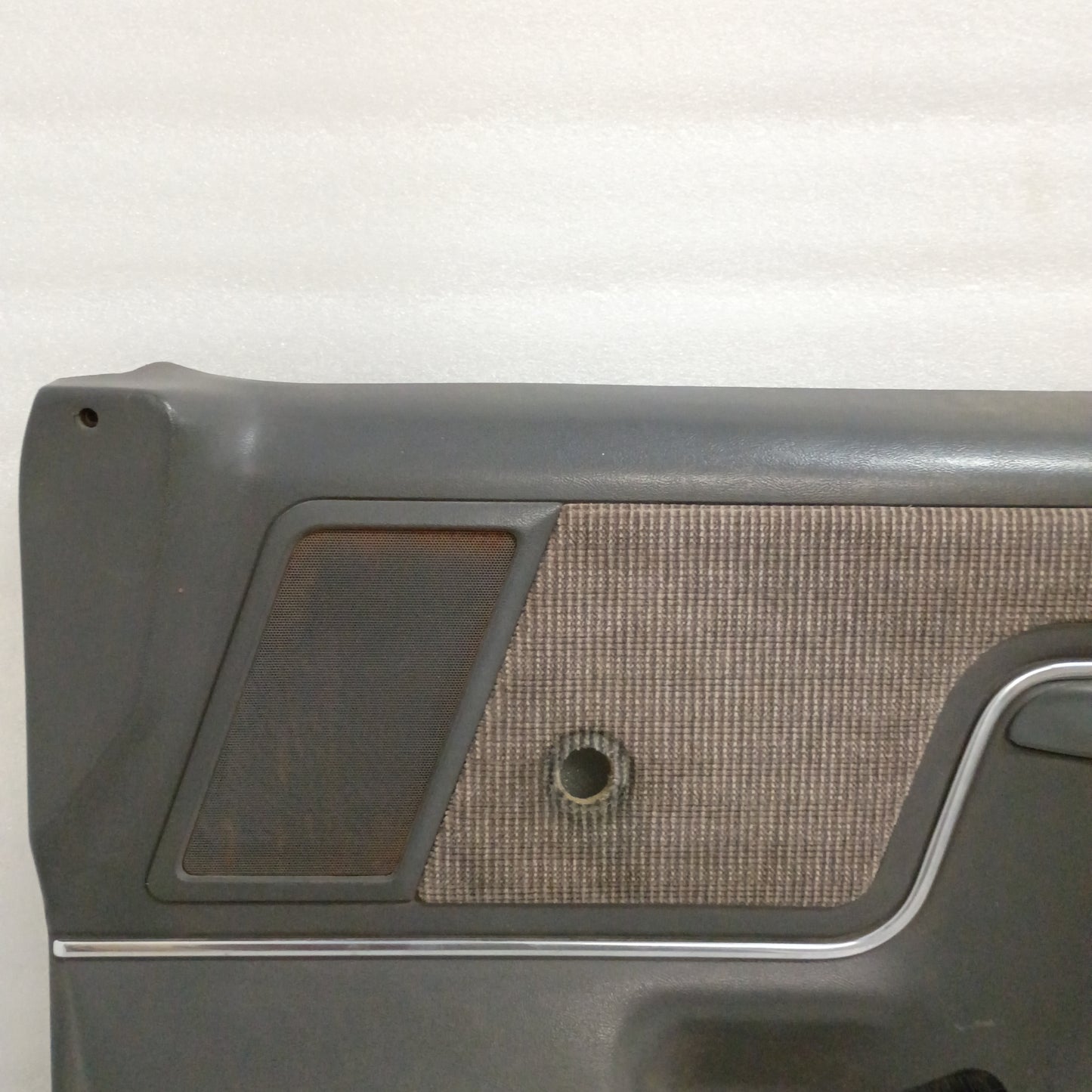 Dark gray door panel for 87-91 Ford F150, F250, F350, Bronco. Features manual window, carpeted map pocket, chrome trim.