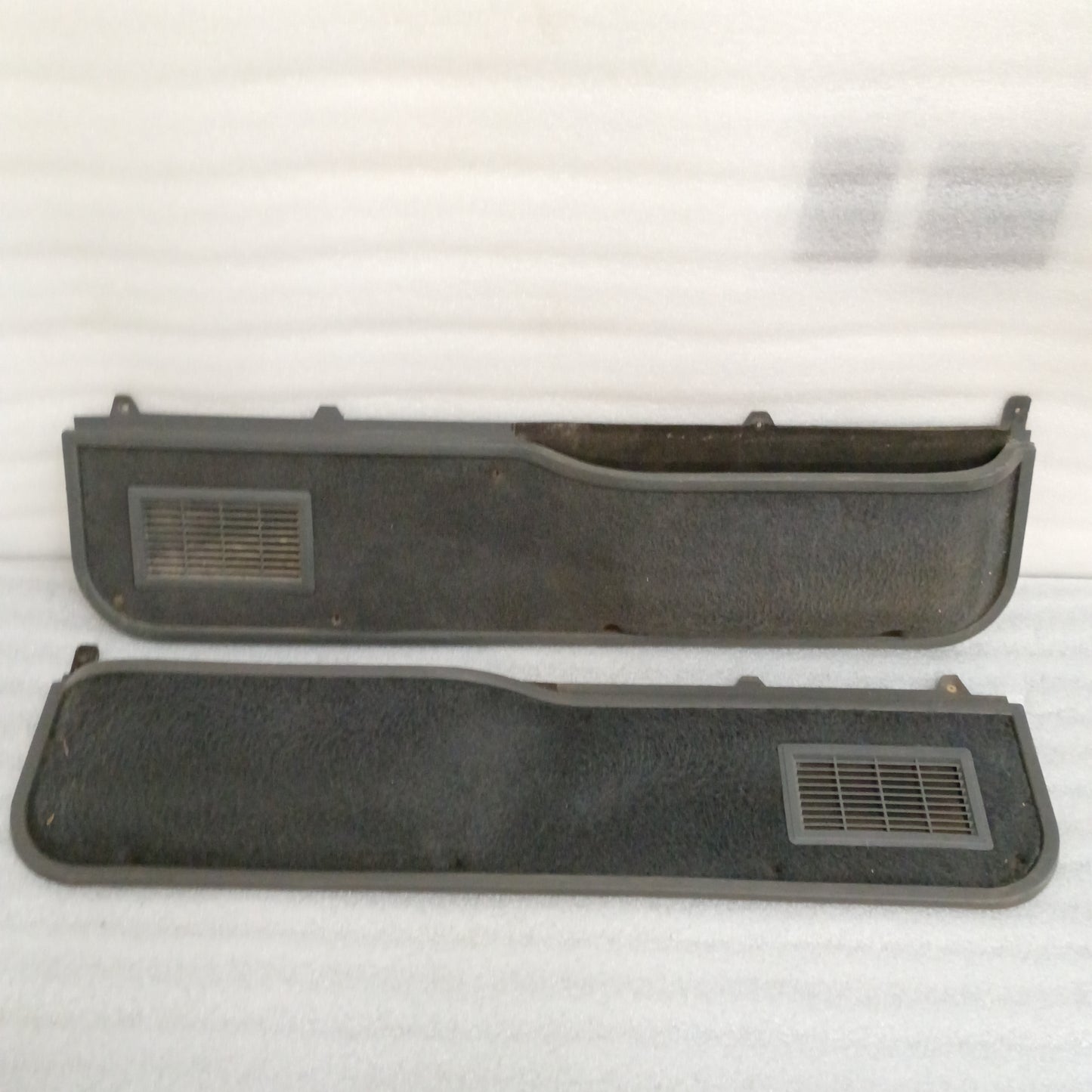 Ford deluxe dark gray door panels set with manual window openings, speaker grilles, and carpeted map pocket inserts.