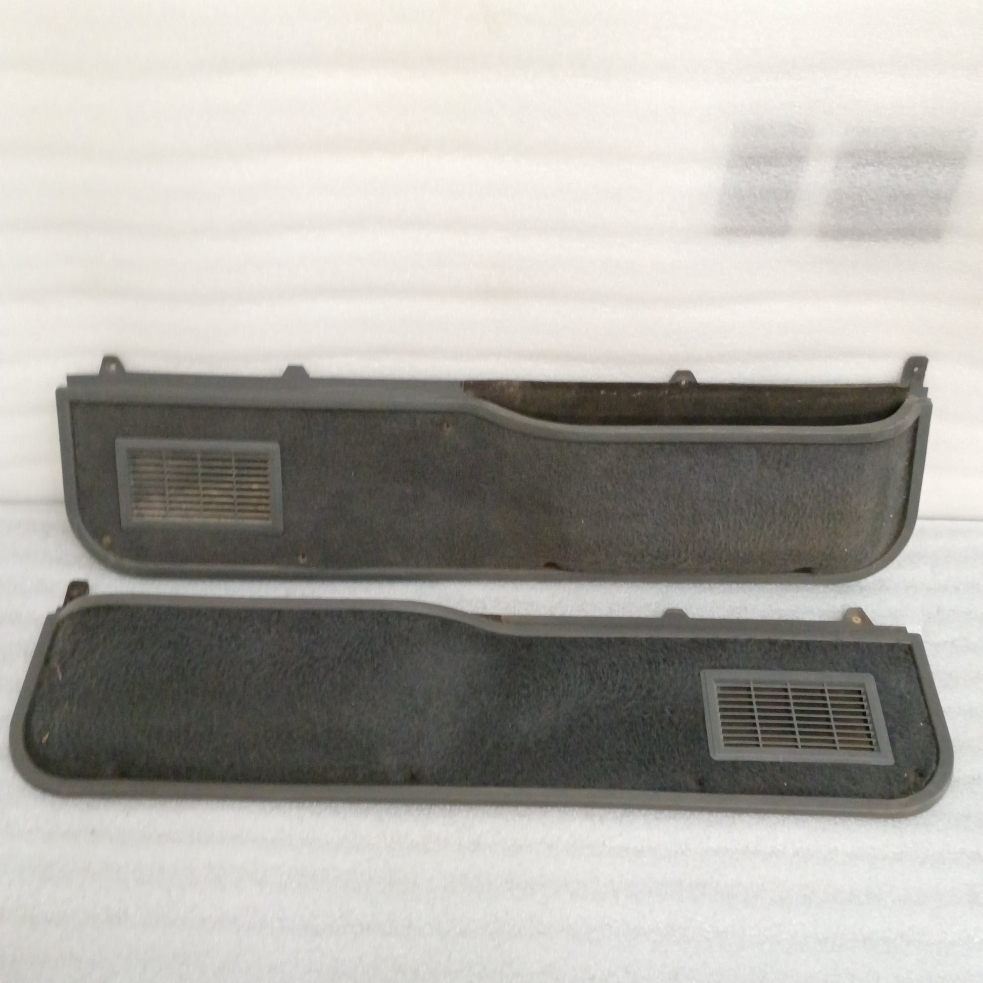 Ford deluxe dark gray door panels set with manual window openings, speaker grilles, and carpeted map pocket inserts.