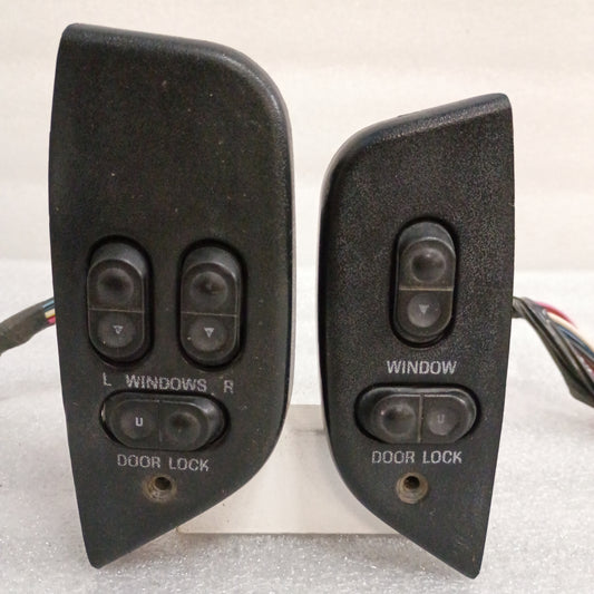 Left and right black power window and door lock switches with bezels and short wire pigtail for 1992-1996 Ford models.