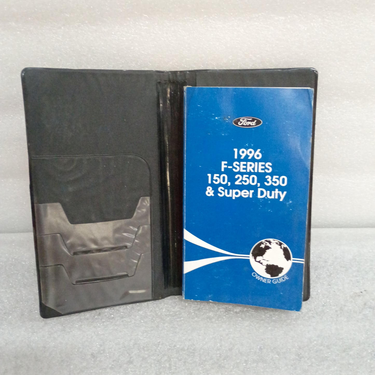 1996 Ford F-Series Owner Guide and cover case for F-150, F-250, and F-350, in good used condition with some wear.