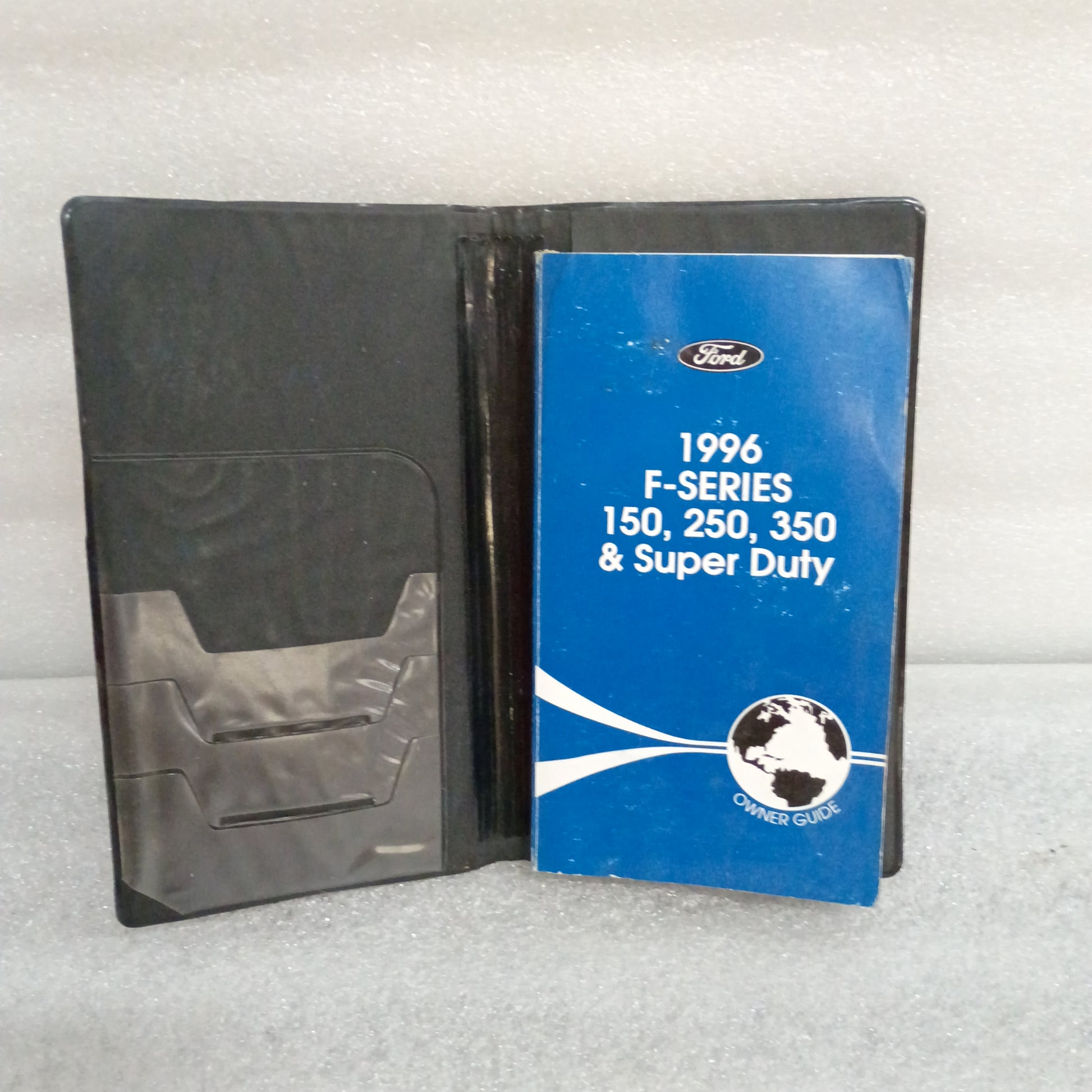 1996 Ford F-Series Owner Guide and cover case for F-150, F-250, and F-350, in good used condition with some wear.