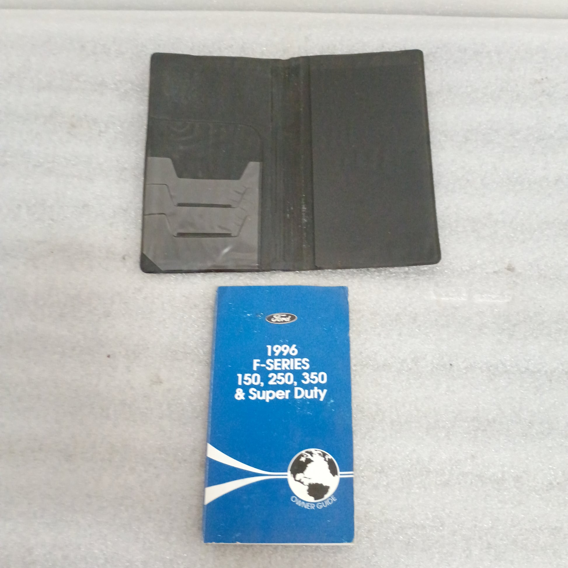 1996 Ford F-Series Owner Guide and black case set for F150, F250, F350, showing some external wear, in good used condition.