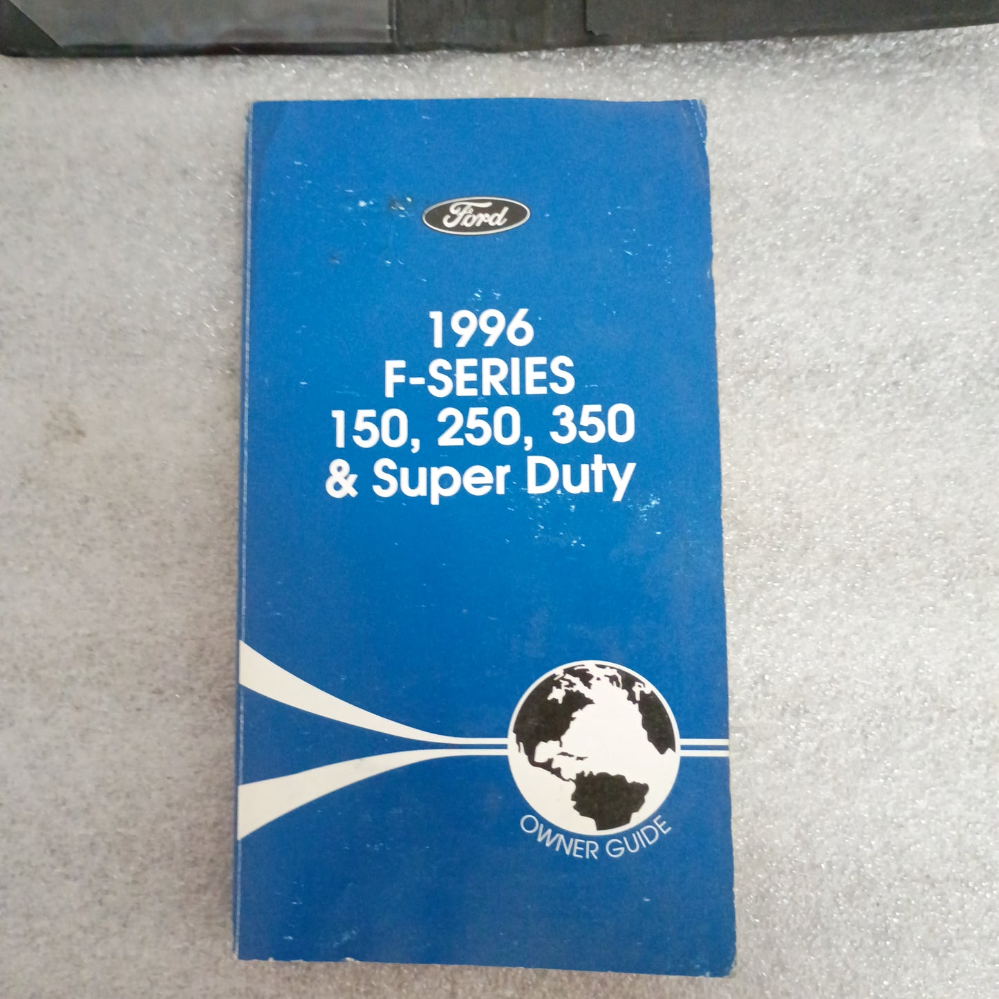 1996 Ford F-Series Owner Guide for F-150, F-250, F-350; blue cover with globe graphic. Shows some wear.