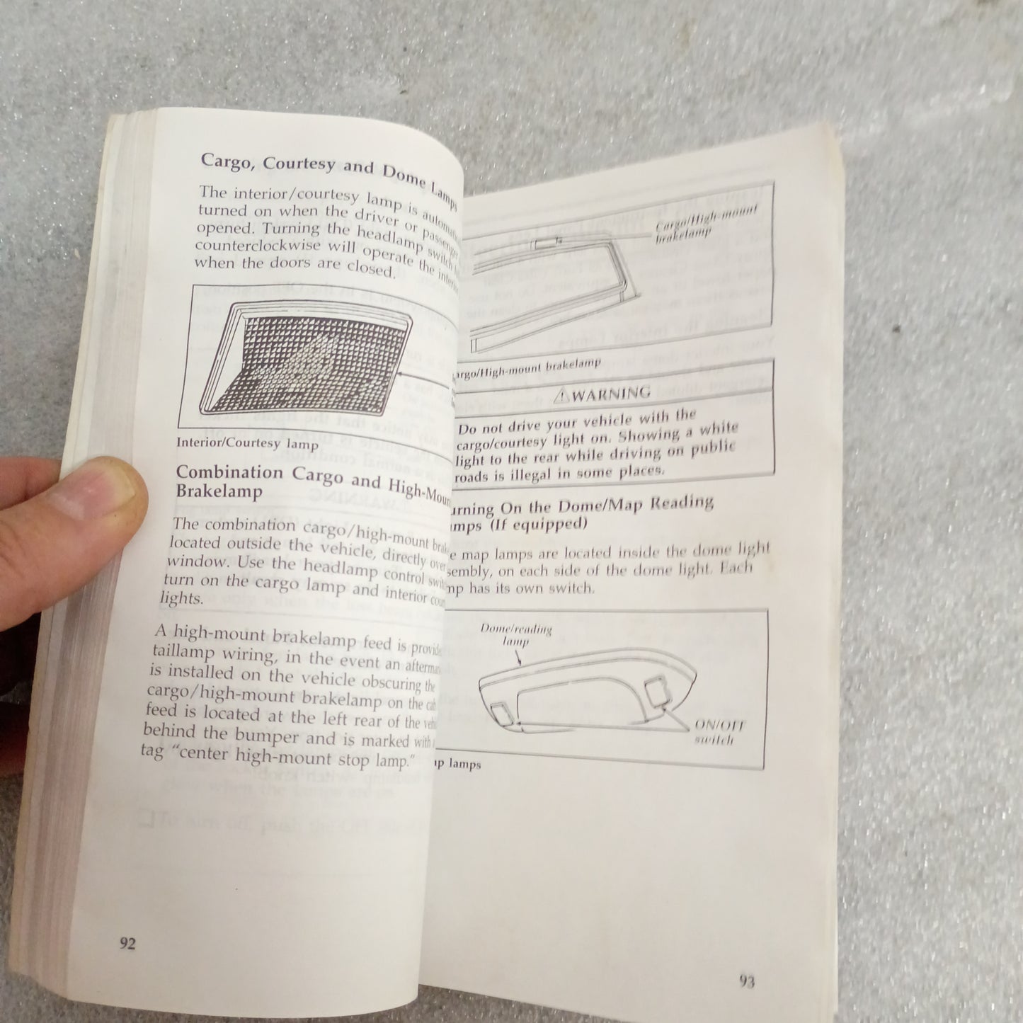 1996 Ford F-Series Owner Guide pages on dome lights, showing diagrams and text; hand holding the book.