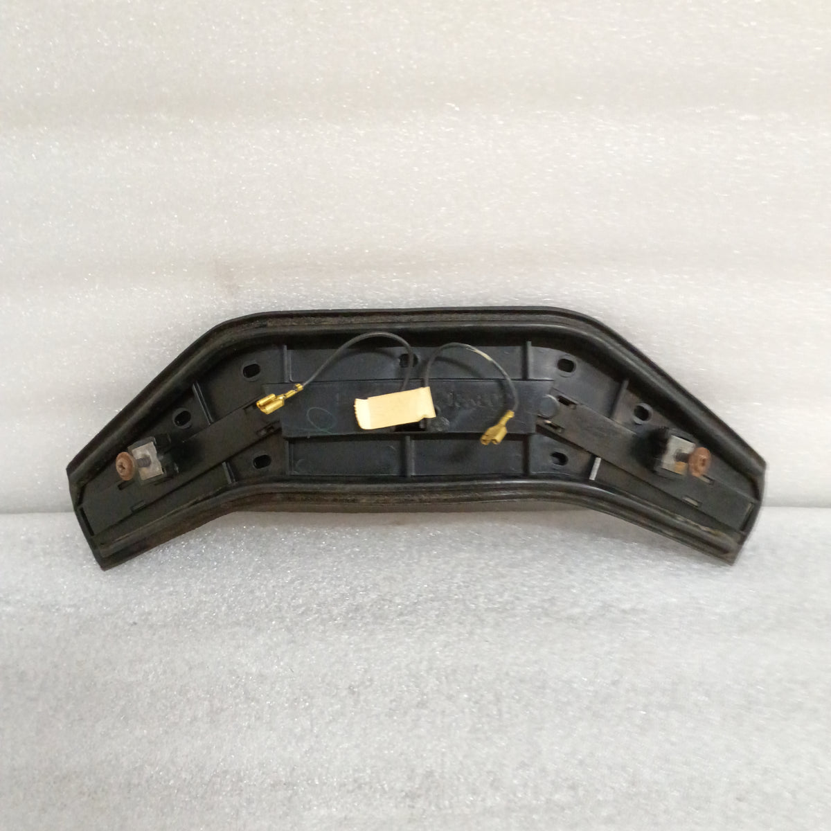 Black OEM horn button for Ford vehicles, mounts to steering wheel, worn vinyl grain, meter-tested, part number 13K803.