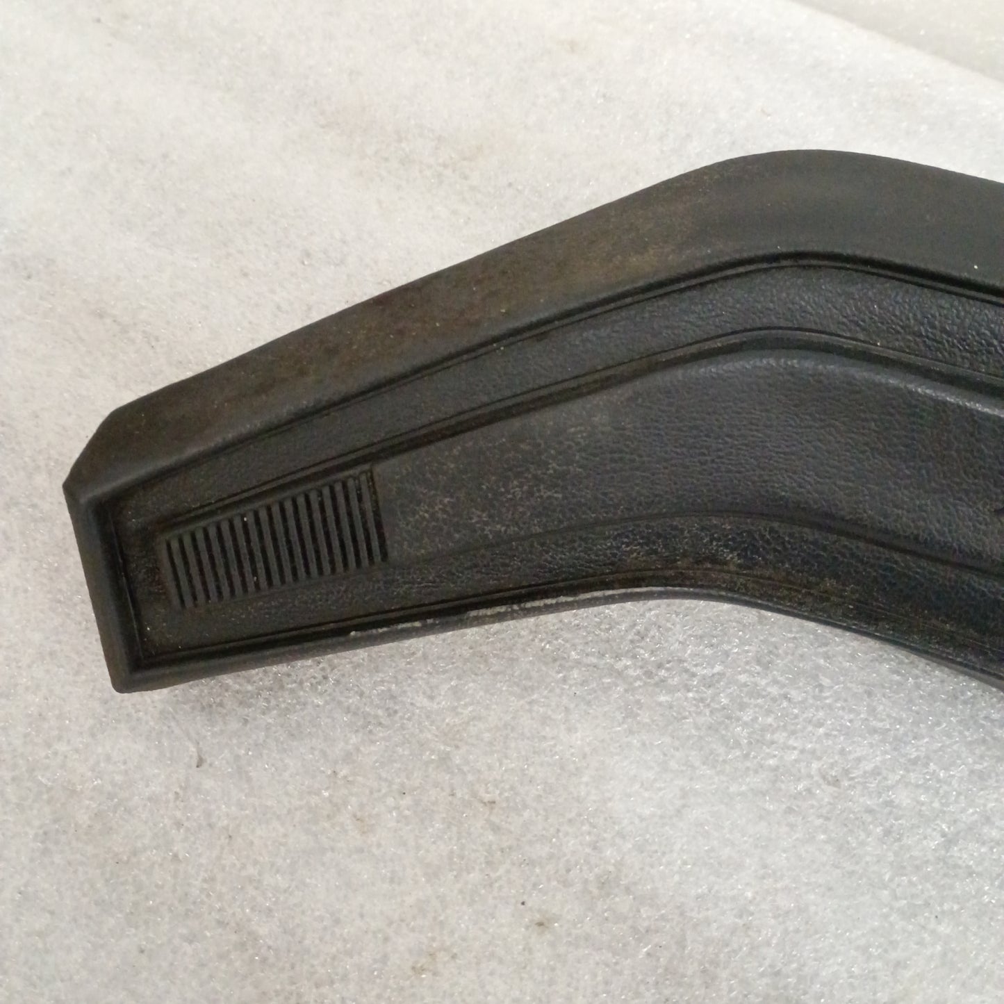 Black vinyl steering wheel horn button with textured grain pattern and worn corners, compatible with 80s Ford trucks and Bronco.