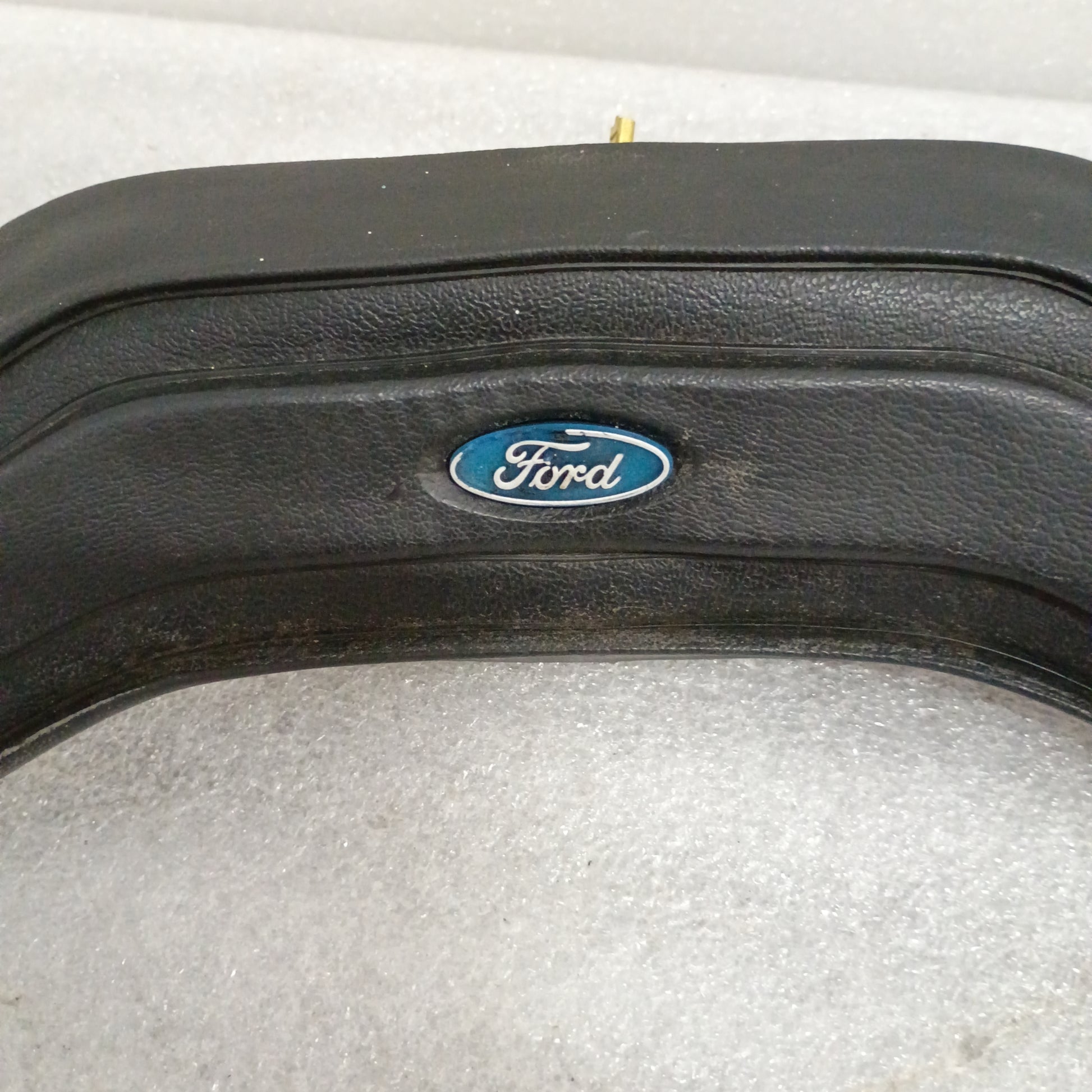 Black Ford steering wheel horn button with logo, fits 80-86 F150, F250, F350, Bronco. Vinyl grain, worn corners, part 13K803.