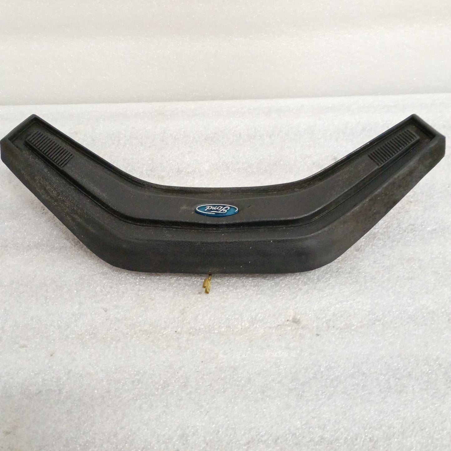 Black Ford steering wheel horn button for 80-86 F150, F250, F350, Bronco. Features vinyl grain and Ford logo in center.