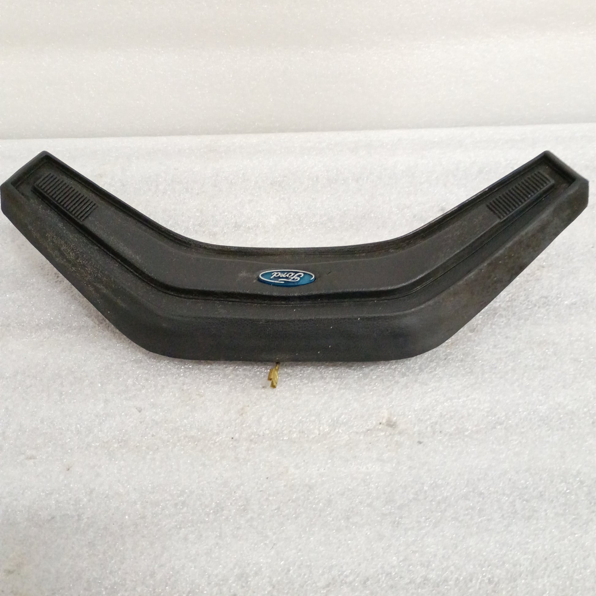 Black Ford steering wheel horn button for 80-86 F150, F250, F350, Bronco. Features vinyl grain and Ford logo in center.