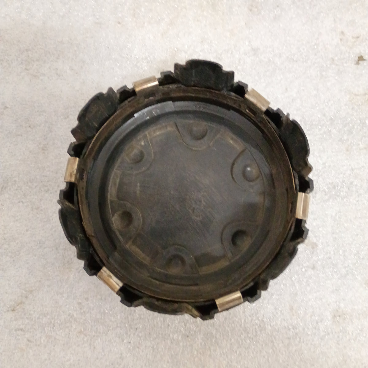 Black Toyota wheel center cap for 86-96 4Runner, Pickup, T100 with automatic disconnect emblem, showing wear and mounting clips.