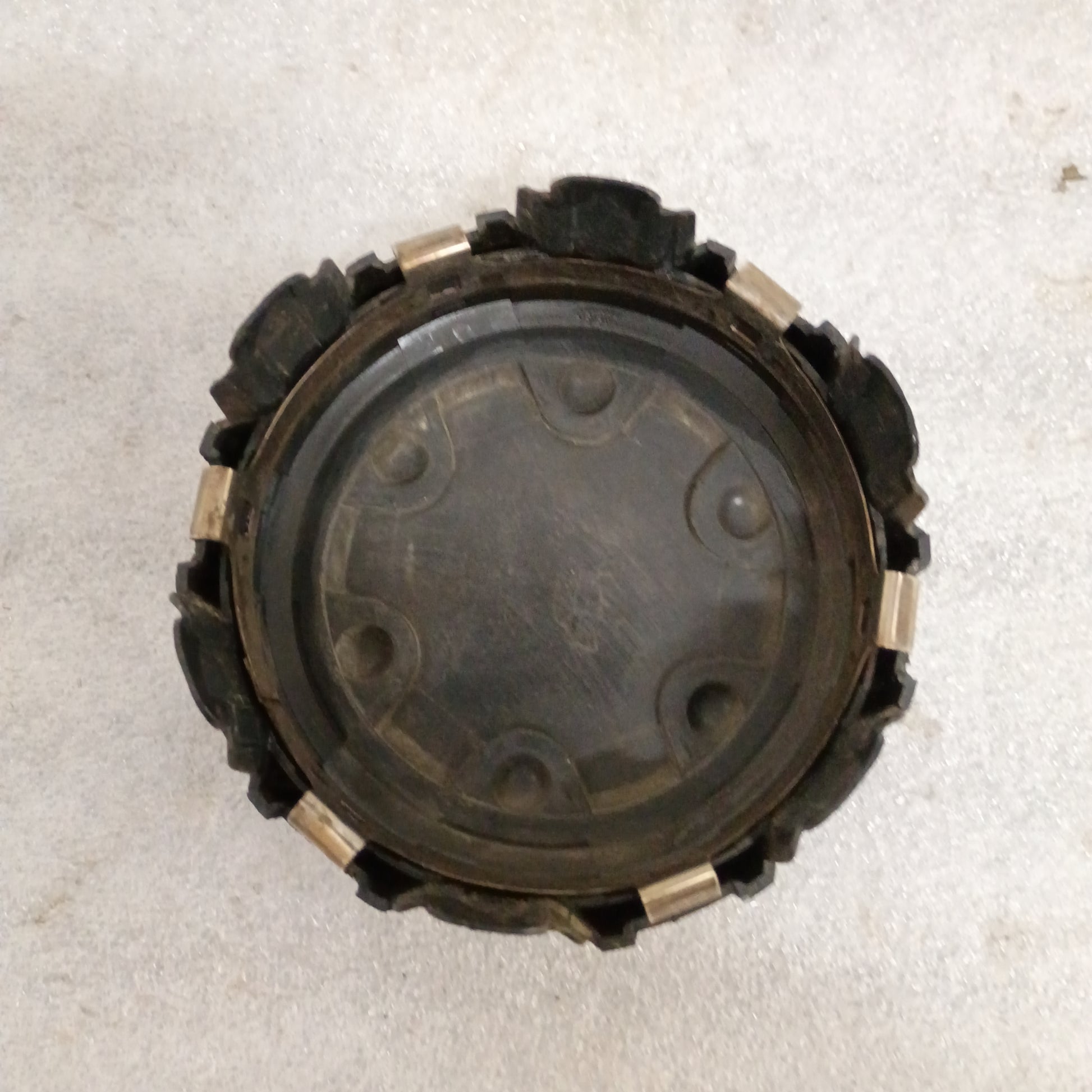 Black Toyota wheel center cap for 86-96 4Runner, Pickup, T100 with automatic disconnect emblem, showing wear and mounting clips.