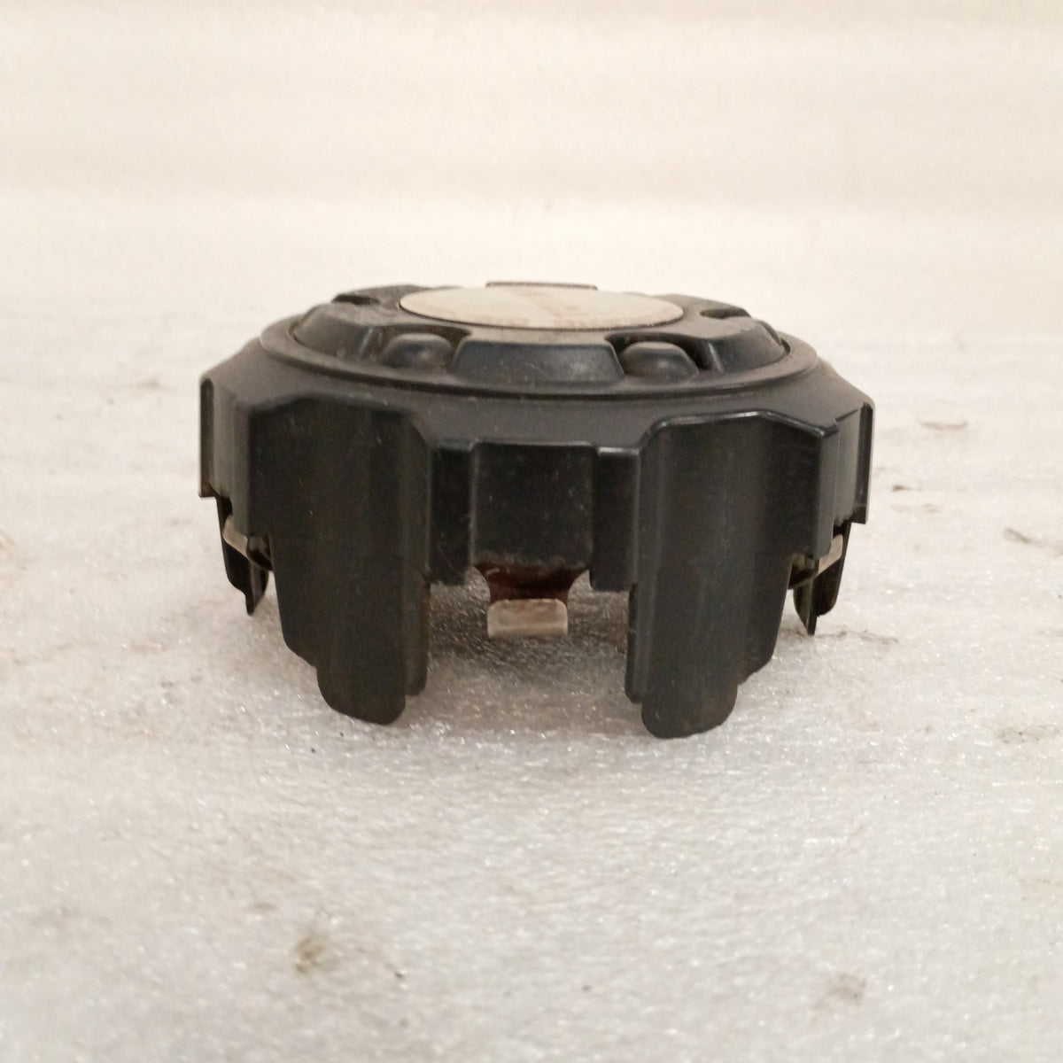 Black Toyota wheel center cap with mounting clips, features Automatic Disconnecting Differential emblem. Fits 86-95 Toyota models.