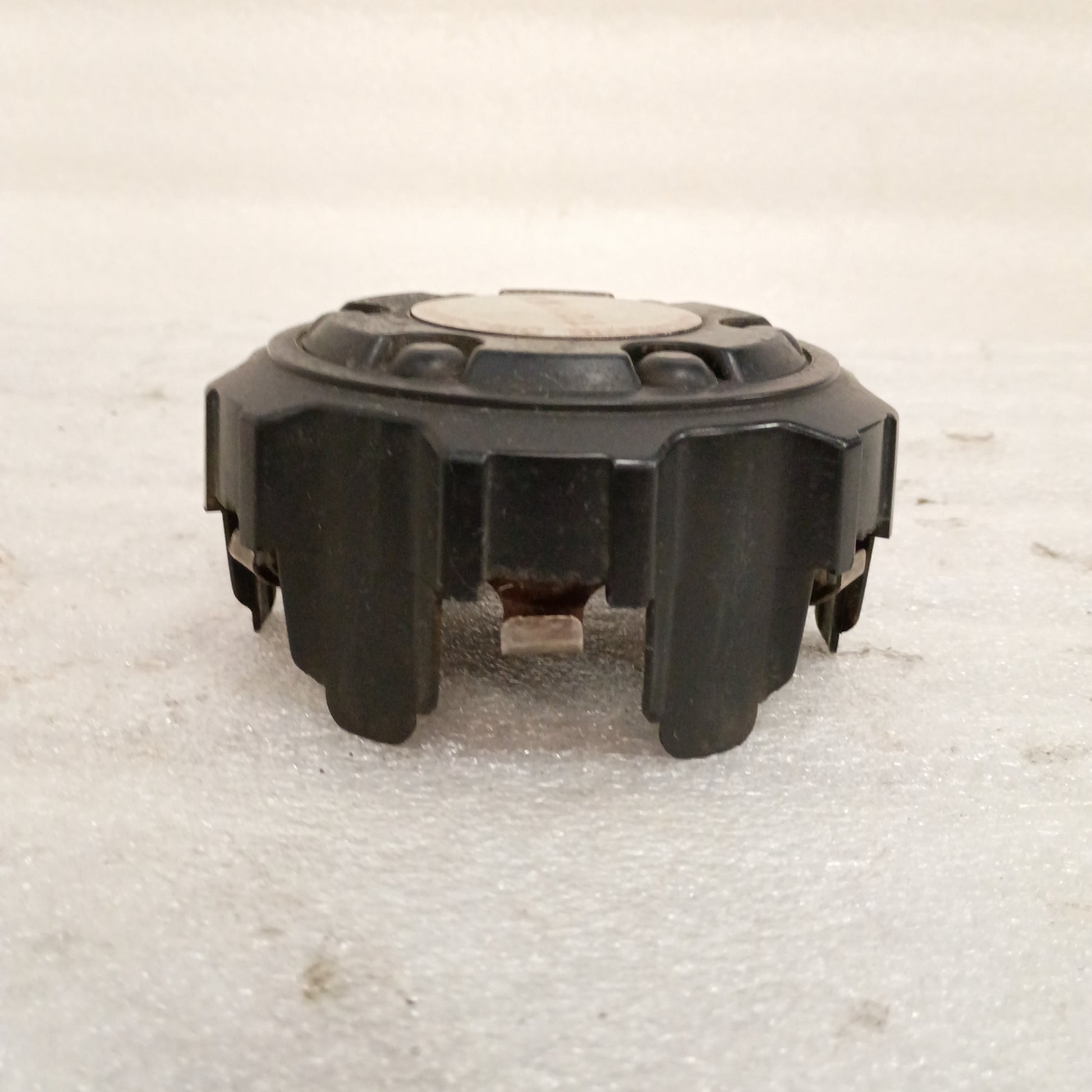 Black Toyota wheel center cap with mounting clips, features Automatic Disconnecting Differential emblem. Fits 86-95 Toyota models.