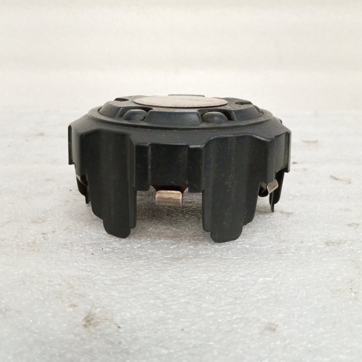 Black Toyota wheel center cap for 1986-1996 4Runner, Pickup, T100 models with automatic disconnecting differential emblem.