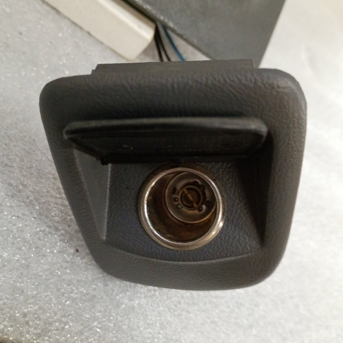 Dark gray ashtray assembly with power port for 1992-1996 Ford F-series and Bronco, includes mounting bracket.