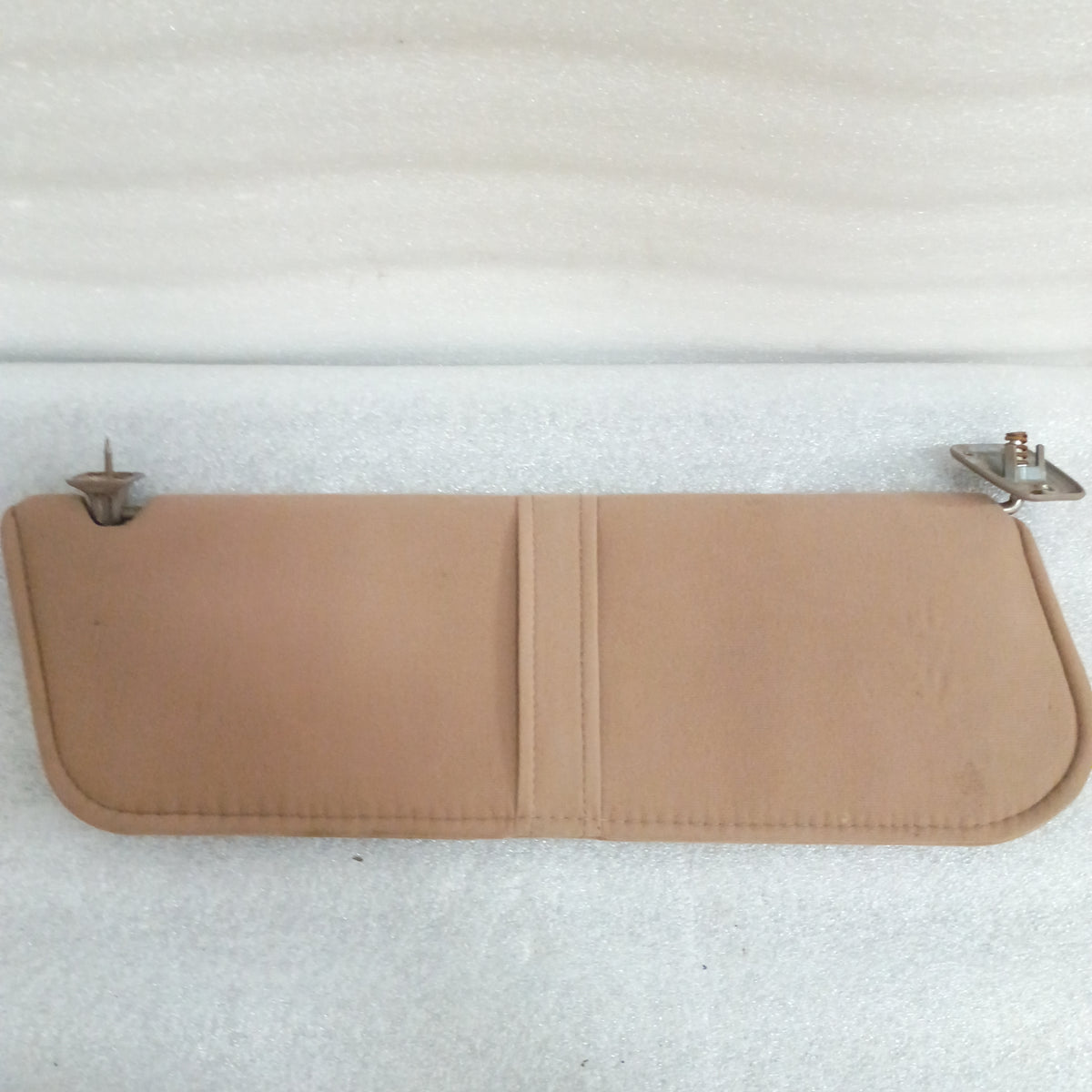 Tan cloth sun visor with mounting hinges for 1992-1997 Ford Bronco/F-Series. Features a cloth loop and minor blemishes.