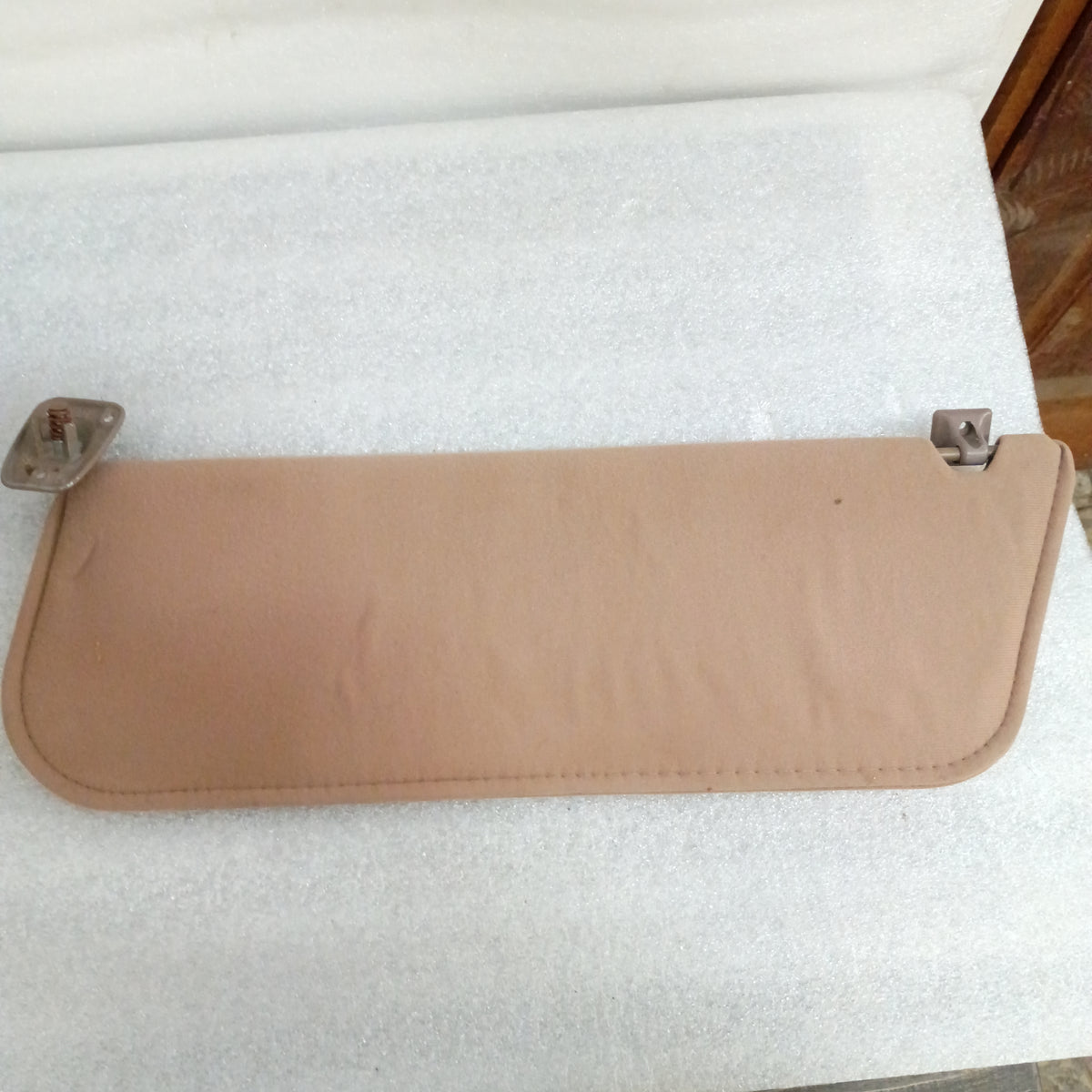 Tan cloth sun visor for 1992-1997 Ford trucks. Includes hinge, minor blemishes. OEM part E0TB-1004122-AWD.